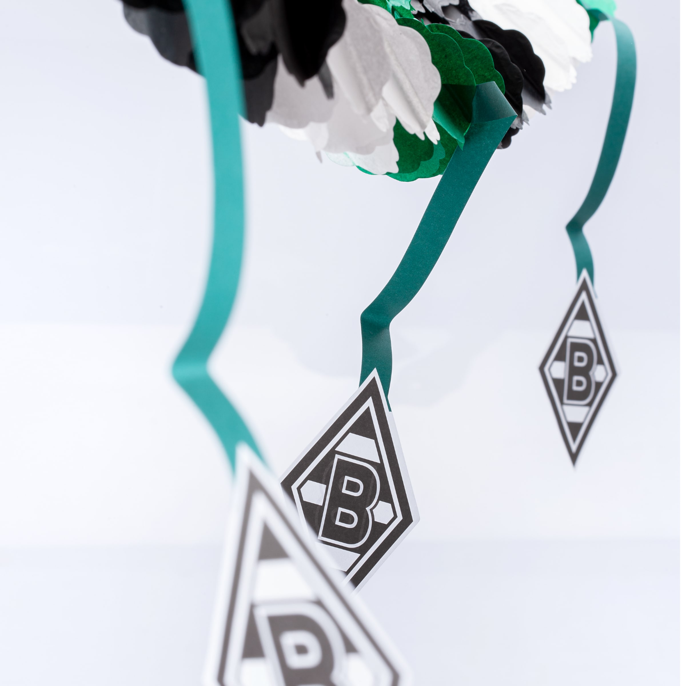 Grüne Hängedekoration mit Borussia Mönchengladbach Logos an Spiralbändern vor weißem Hintergrund.