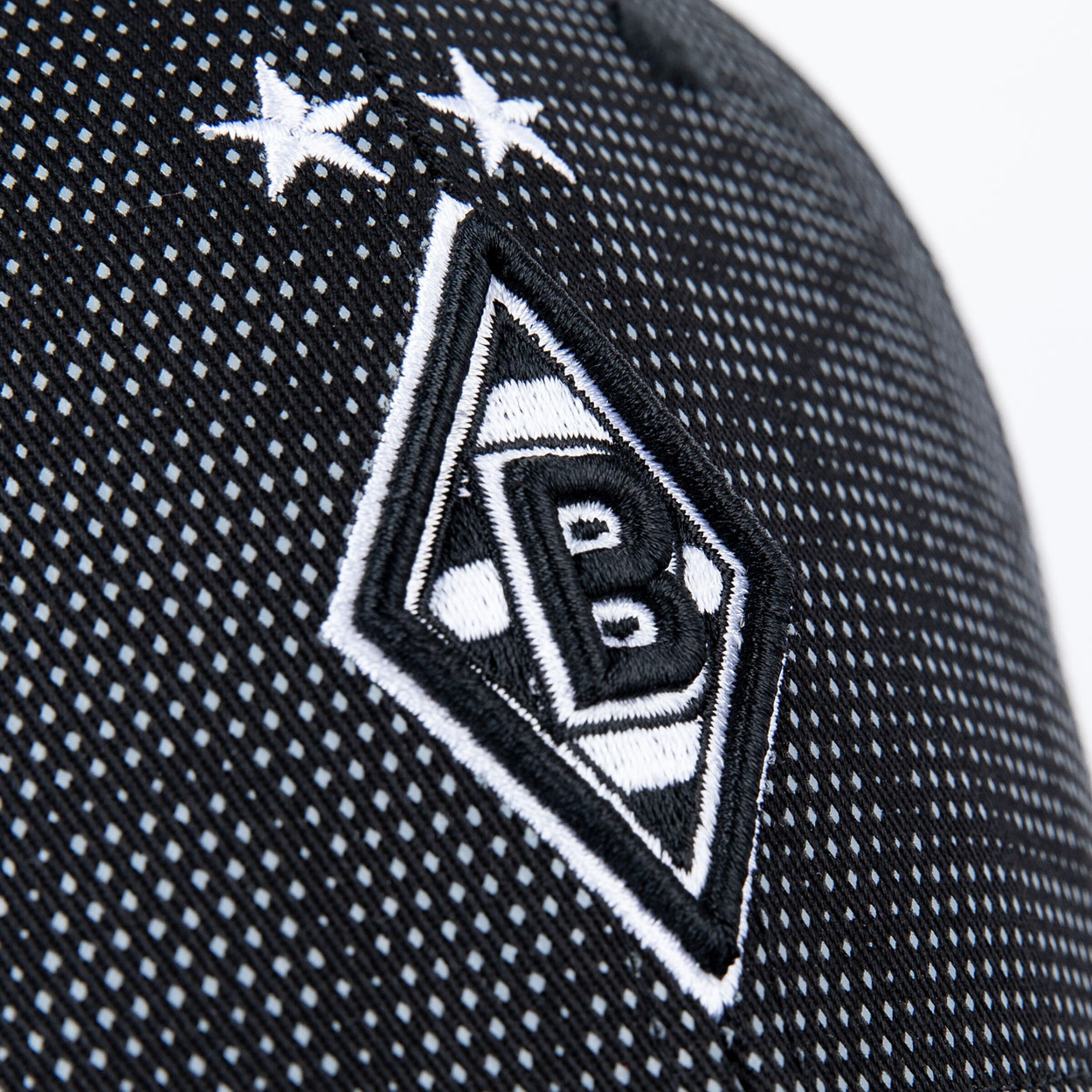 Detailaufnahme des Borussia Mönchengladbach Logos auf einer Mütze mit zwei Sternen.