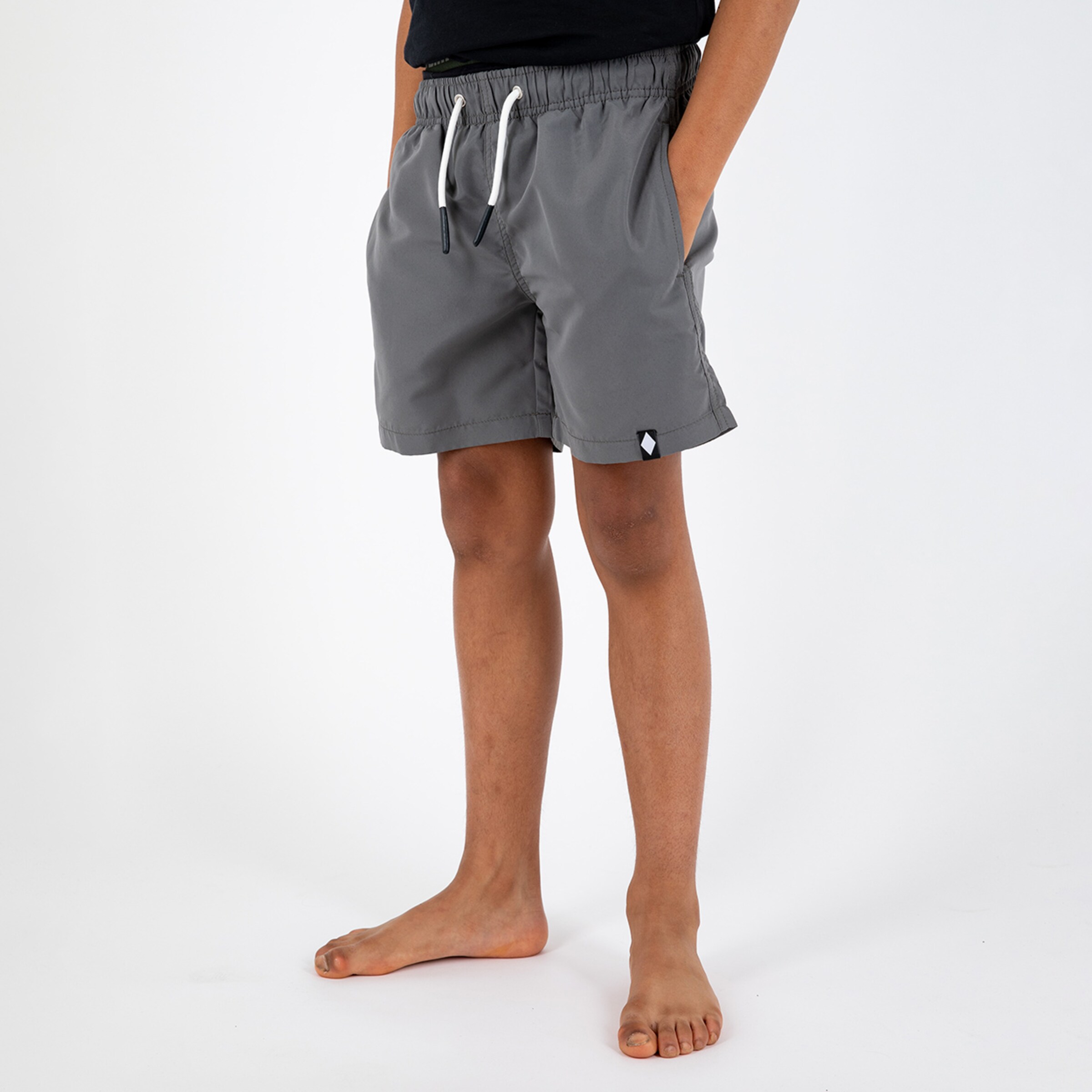 Graue Shorts mit Gummibund und Taschen Modell steht barfuß.