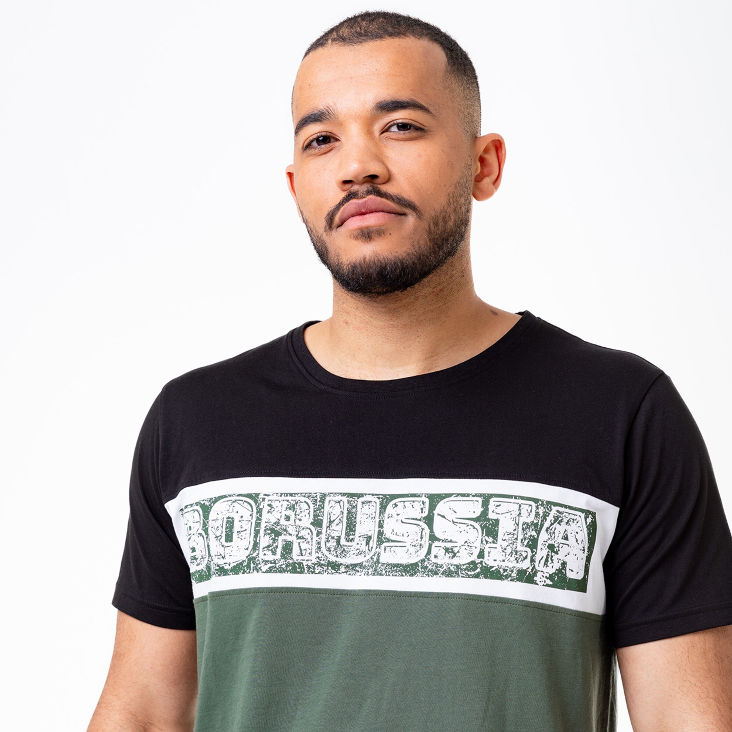 Mann in T-Shirt mit Aufdruck BORUSSIA in Schwarz und Grün.