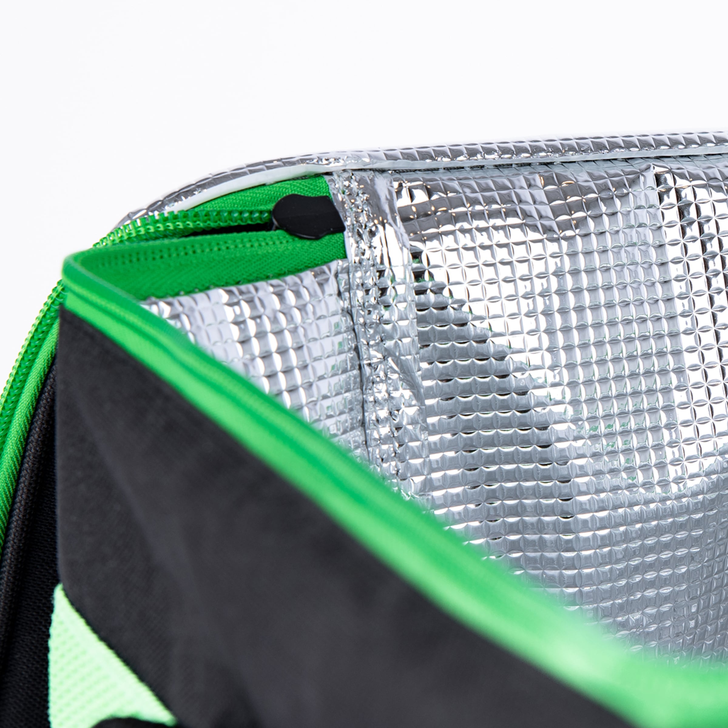 Innenansicht einer Kühltasche mit silberner Thermoisolierung, grünem Reißverschluss und schwarzem Außenstoff.