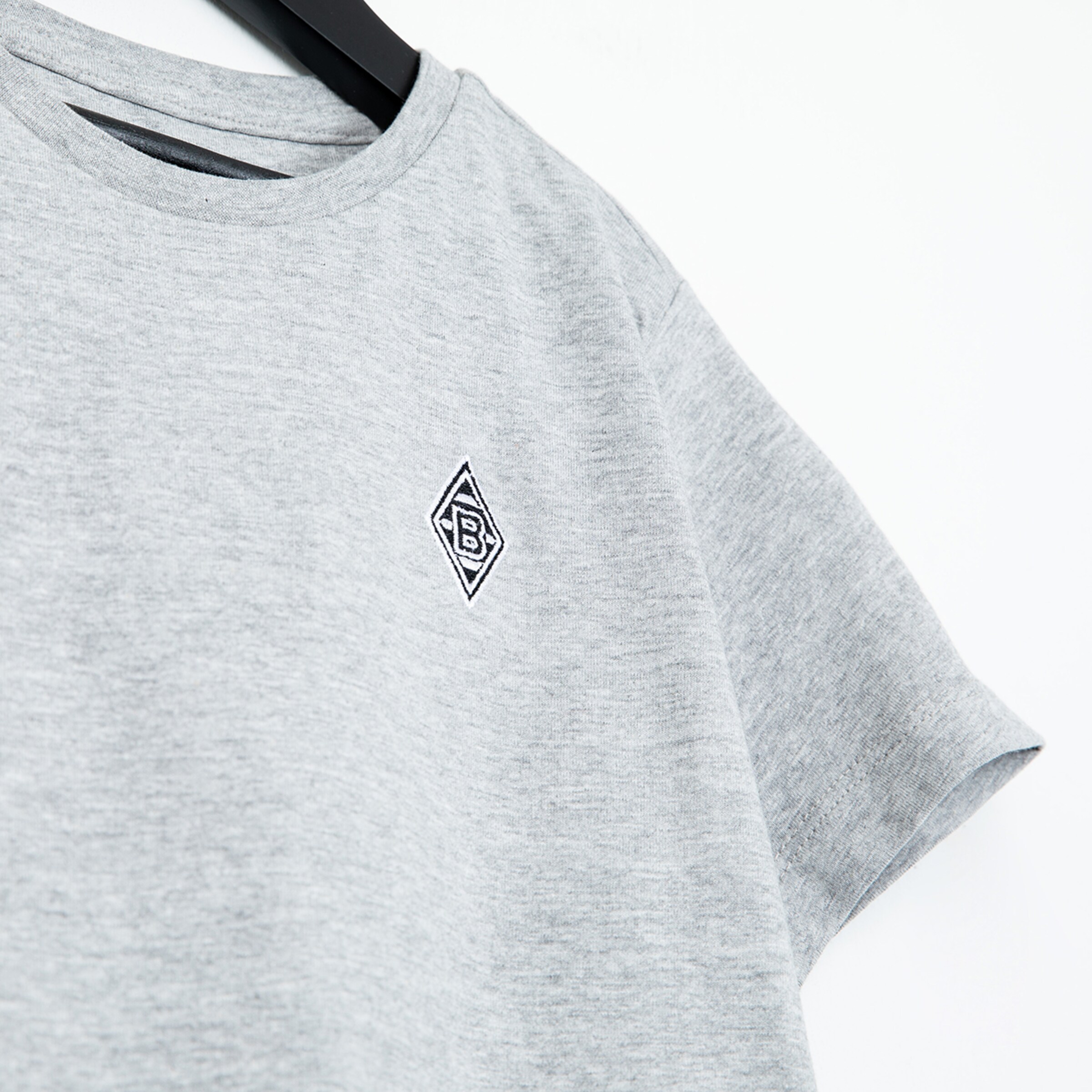 Graues T-Shirt mit gesticktem Borussia Mönchengladbach Logo.
