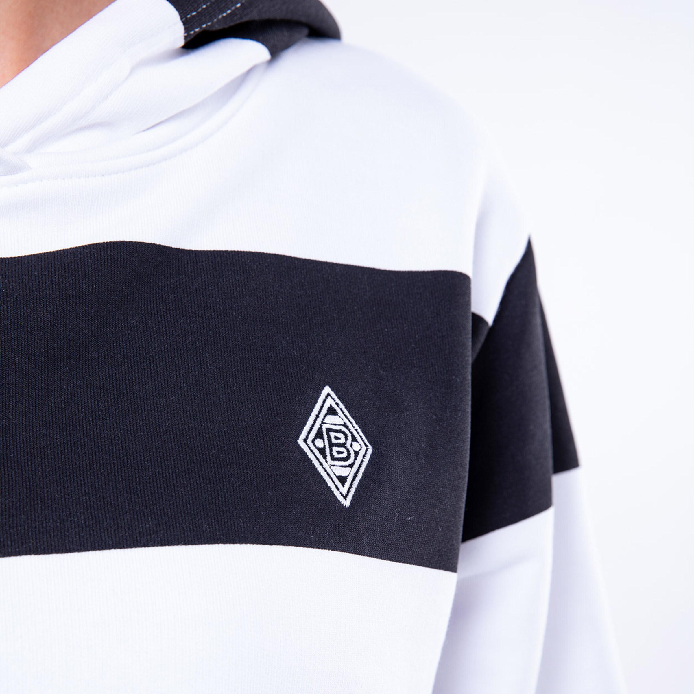 Schwarz-weiße Jacke mit dem Borussia Mönchengladbach Logo auf der linken Brust.