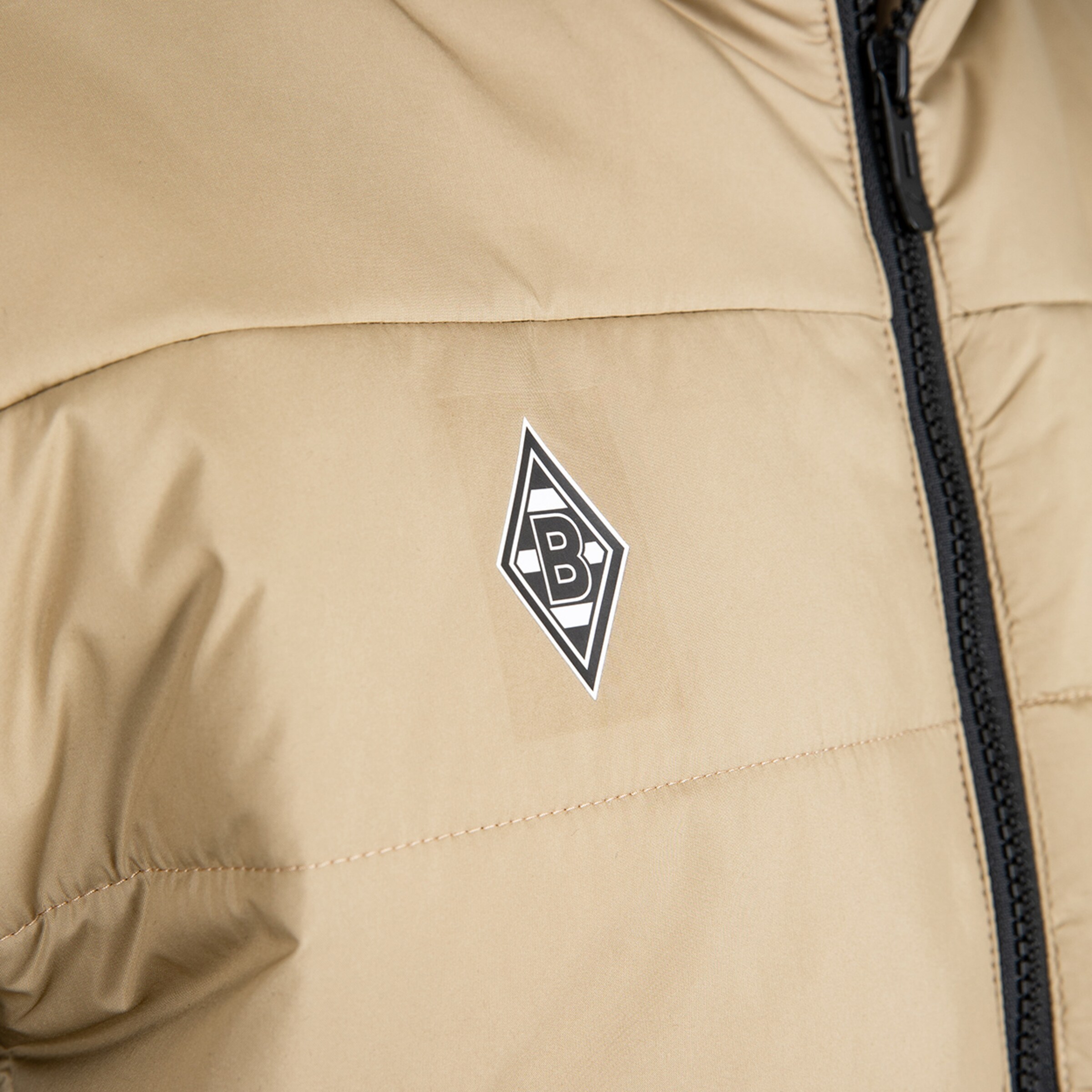 Beige Jacke mit dem Borussia Mönchengladbach-Logo auf der Brust.