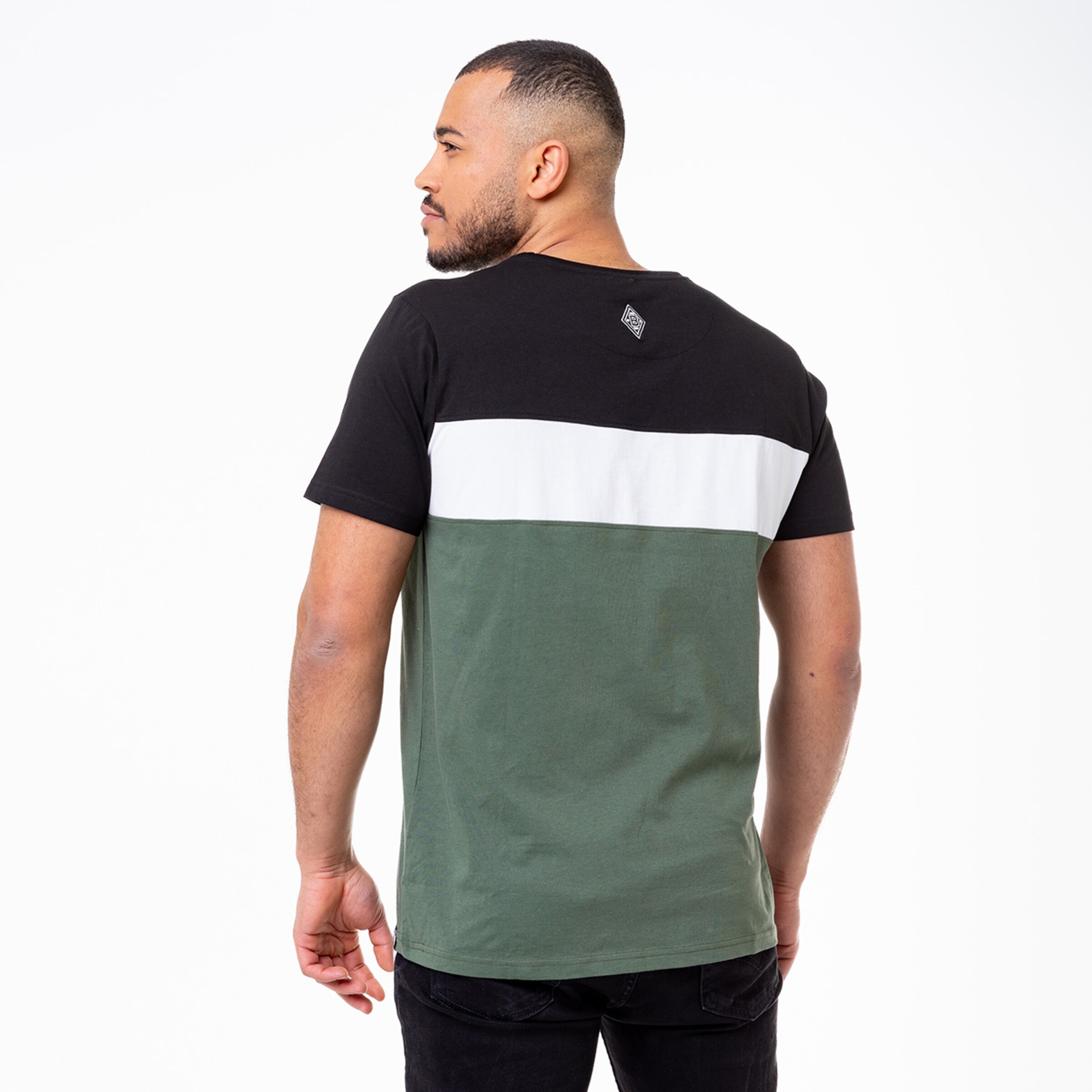 Mann trägt ein T-Shirt in Schwarz Weiß und Grün von hinten fotografiert.