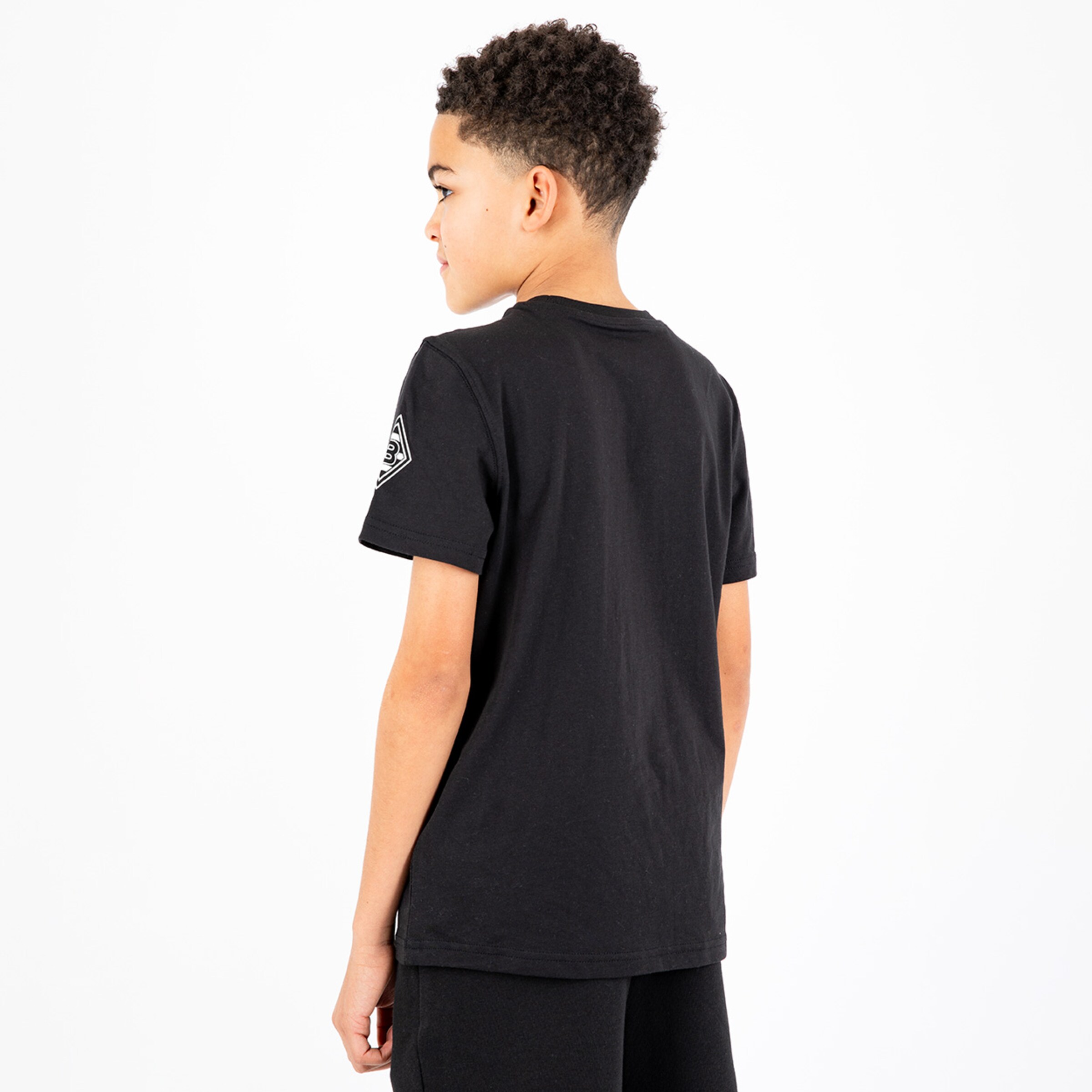 A boy wearing a black t-shirt seen from the back.