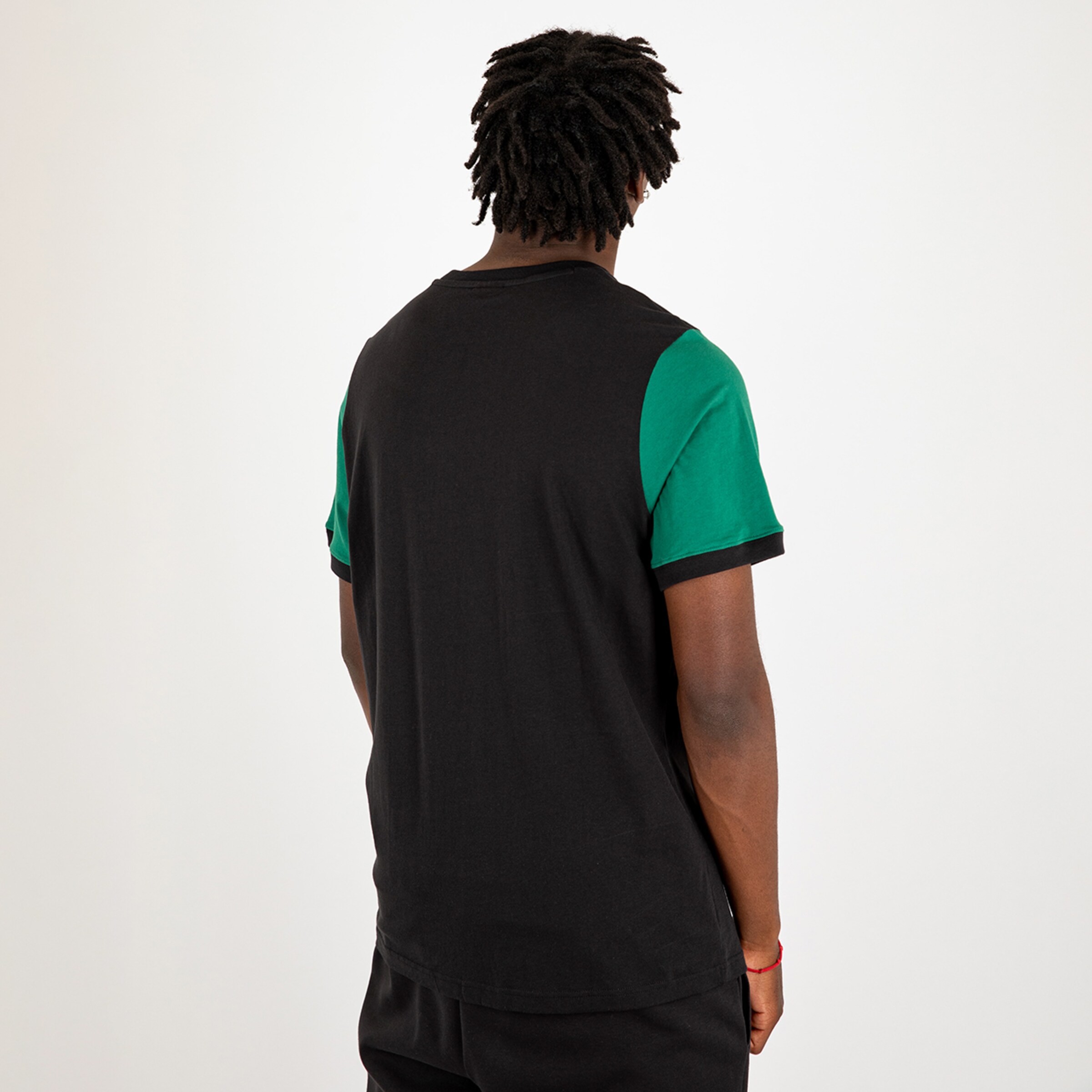 Black t-shirt with green sleeves viewed from the back person with curly hair.