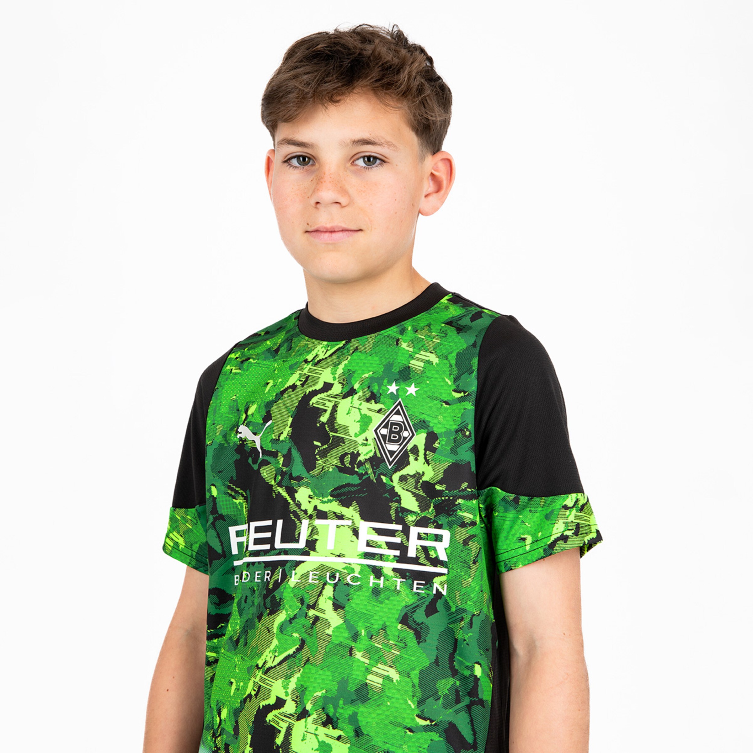 Junger Fußballspieler trägt ein grünes Trikot mit schwarzem Detail und dem Logo von Borussia Mönchengladbach.