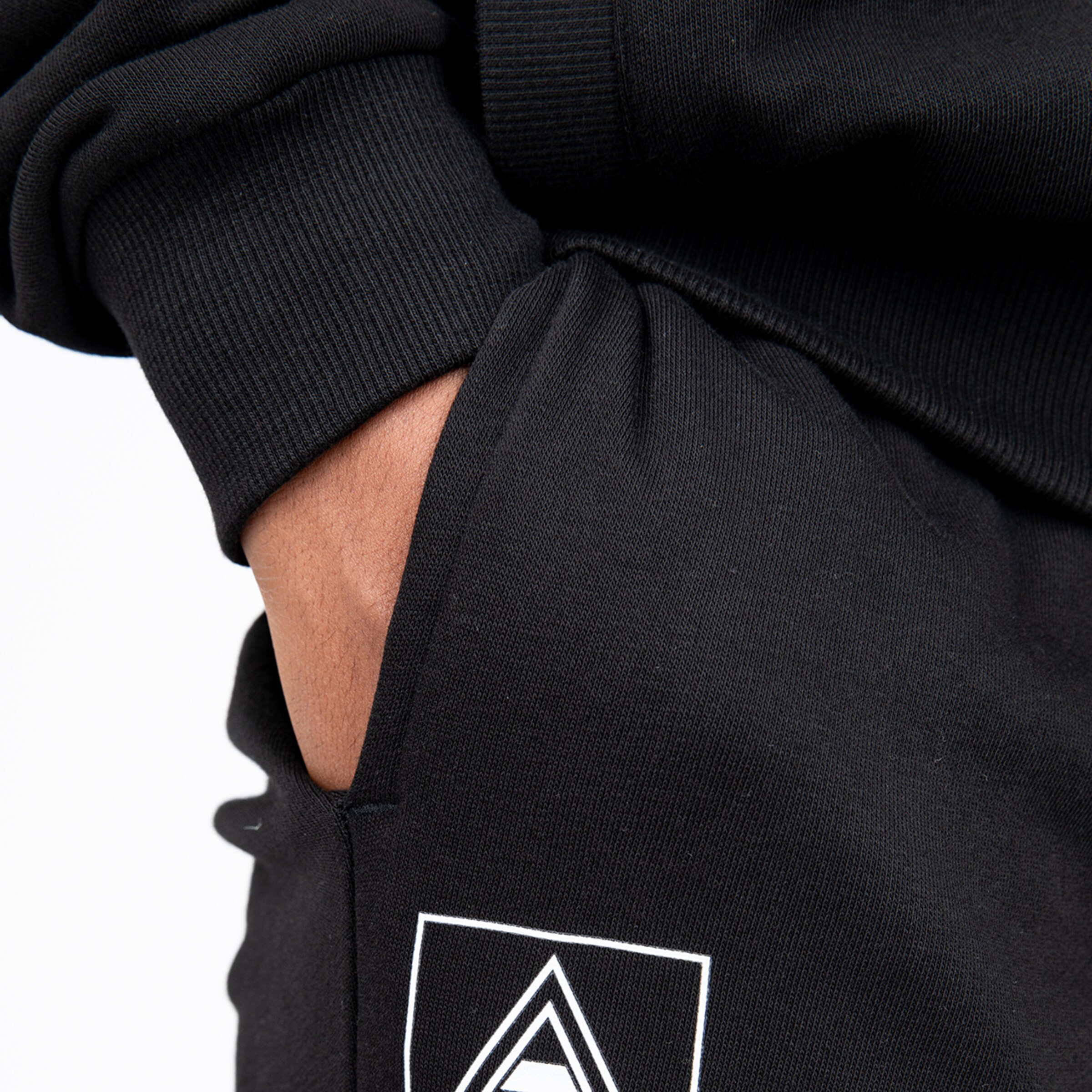 Seam of a black sweatshirt with a hand in the pocket.