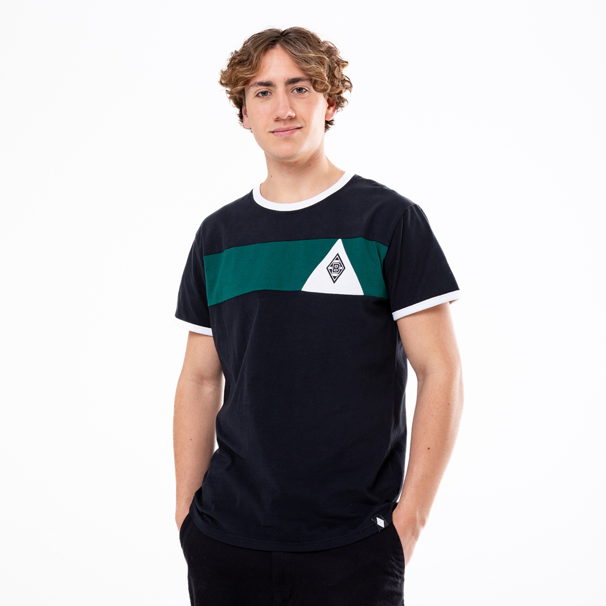 Junger Mann in einem dunkelblauen T-Shirt mit grünem Streifen und einem weißen Dreieck.