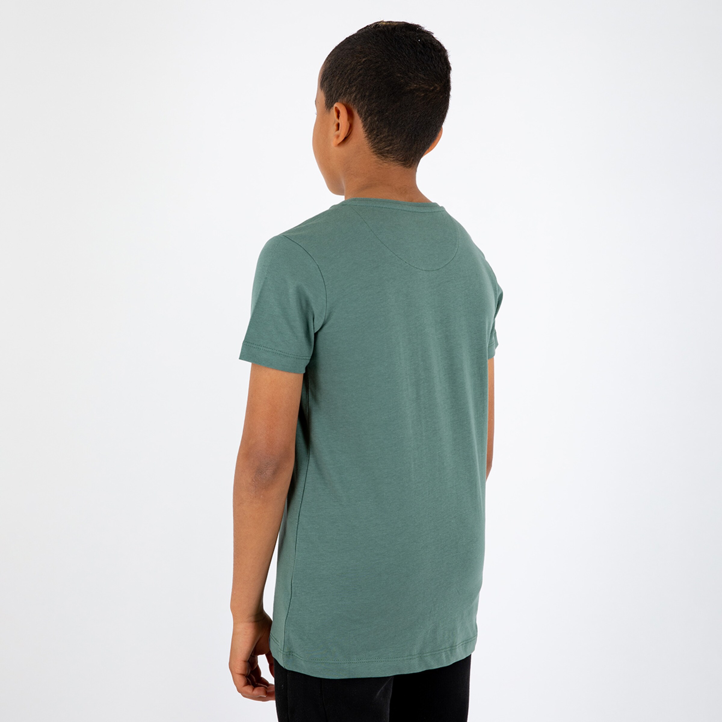 Junge von hinten in grünem T-Shirt schwarze Hose.