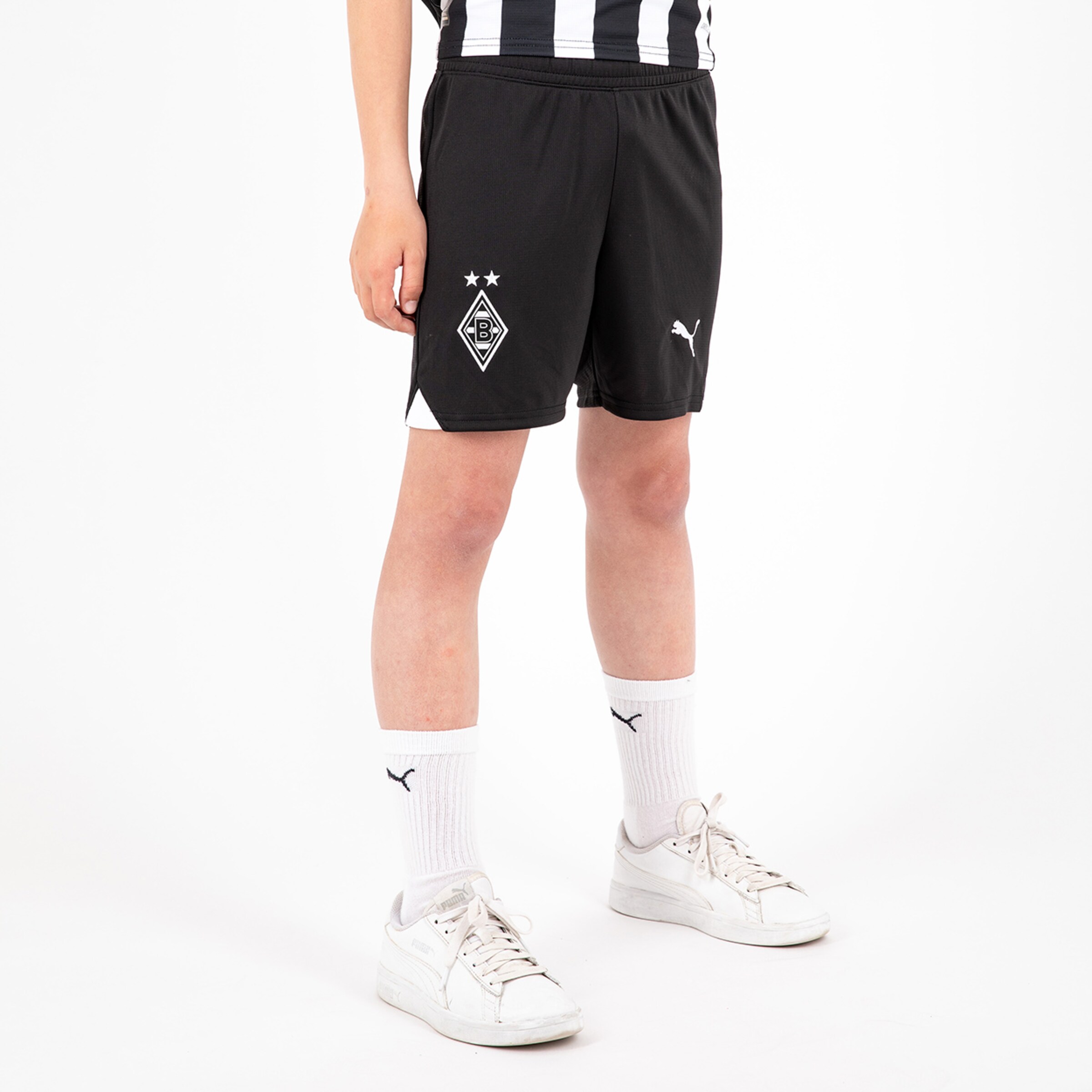 Black football shorts featuring Borussia Mönchengladbach logo worn by a person.