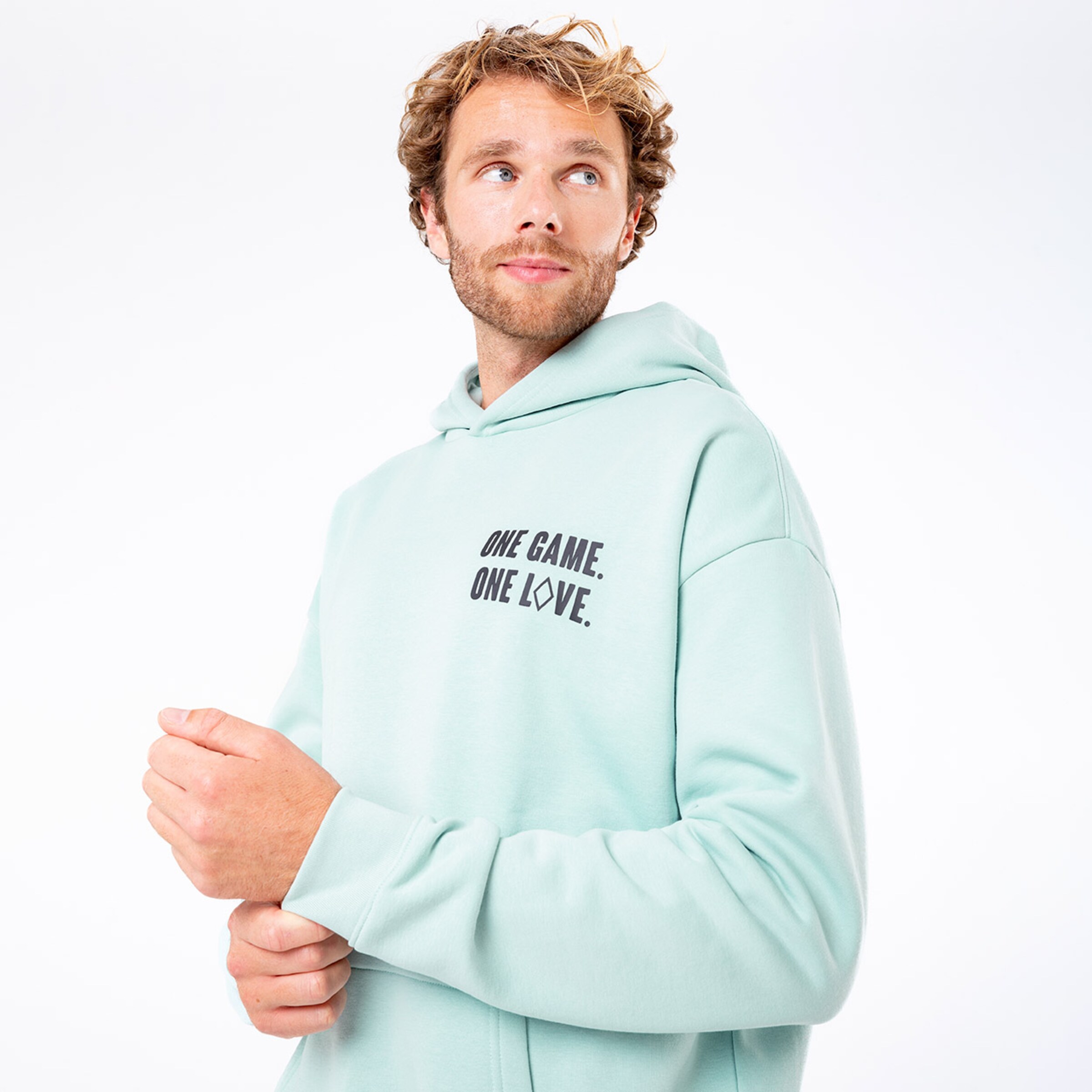 Mann in mintgrüner Kapuzenjacke mit dem Aufdruck ONE GAME. ONE LOVE.