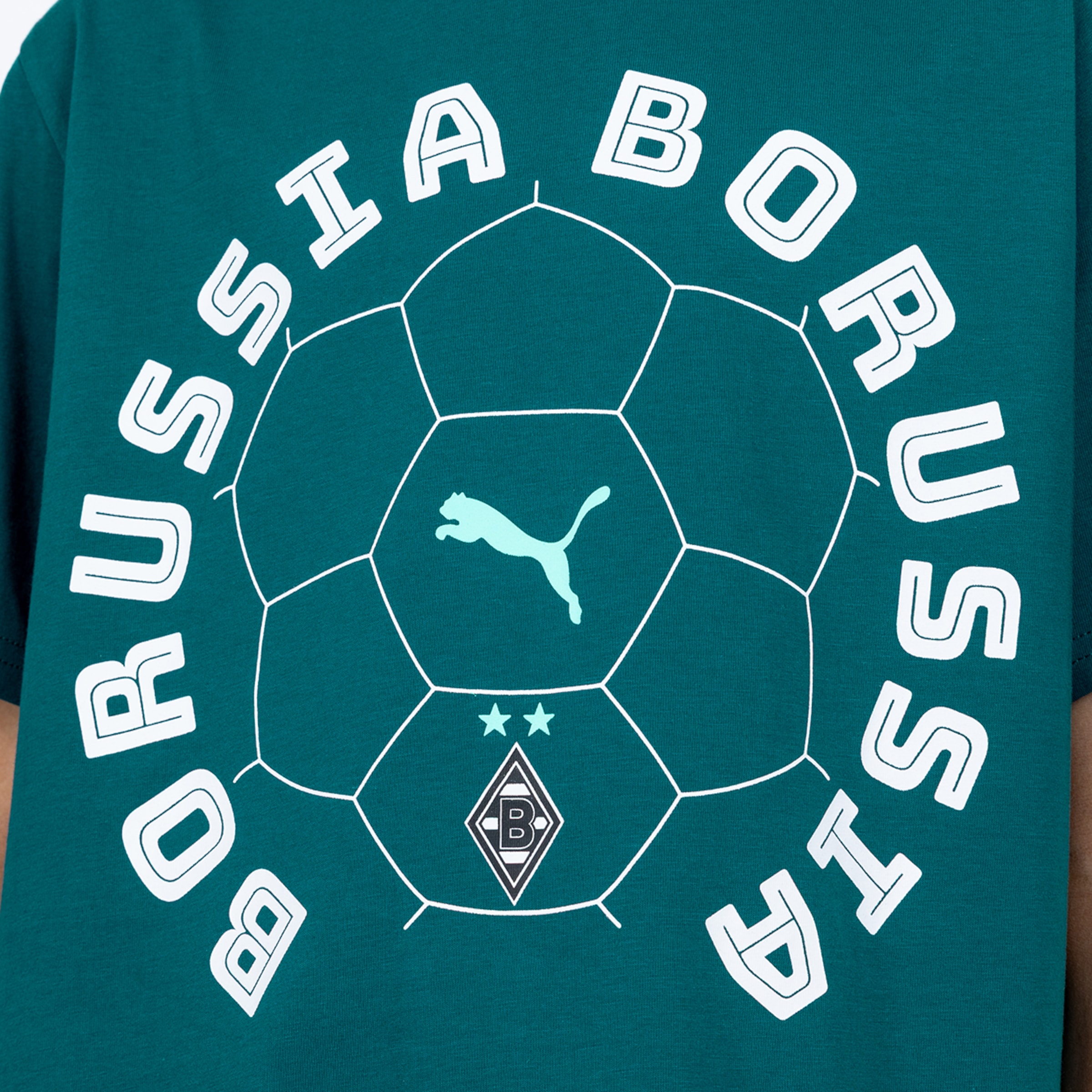 Dunkelblaugrünes T-Shirt mit weißer Fußballumrandung. Innen: hellblaues Puma-Logo, zwei Sterne und das Borussia Mönchengladbach Wappen. Das Wort 'BORUSSIA' in weißen, umrandeten Buchstaben umgibt den Ball.