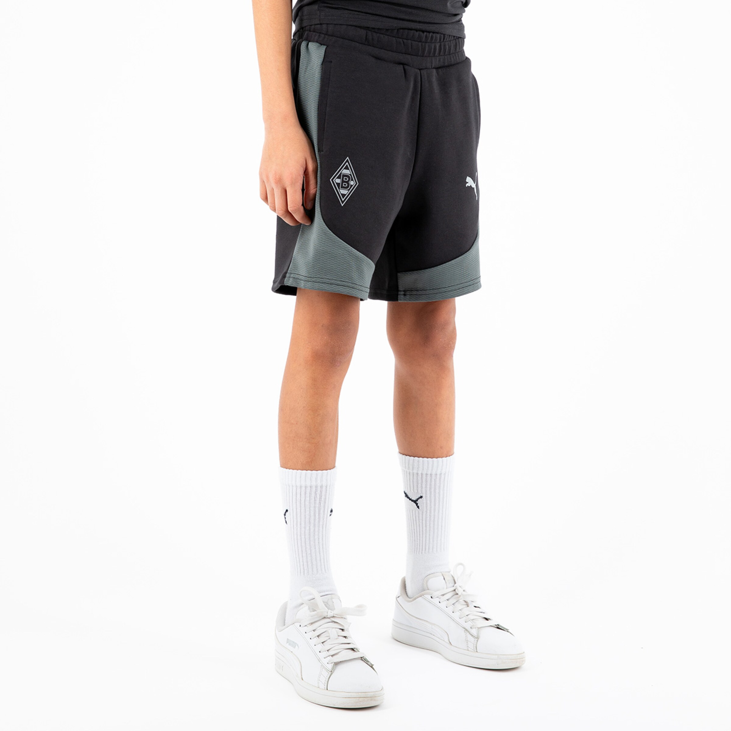 Black and gray sports shorts featuring Borussia Mönchengladbach logo paired with white socks and shoes.