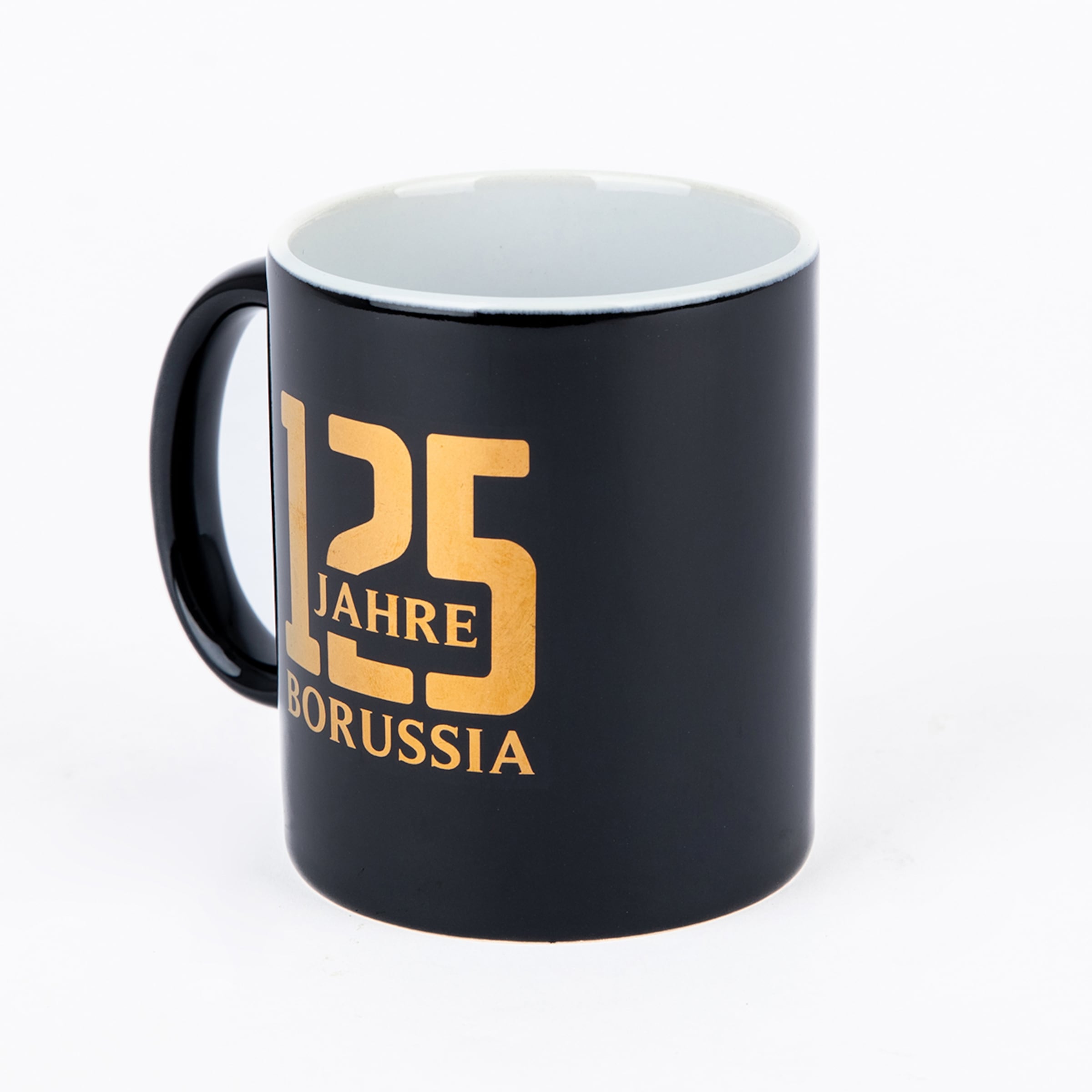 Schwarze Tasse mit weißem Inneren und goldenem Aufdruck „125 JAHRE BORUSSIA“ auf weißem Hintergrund.