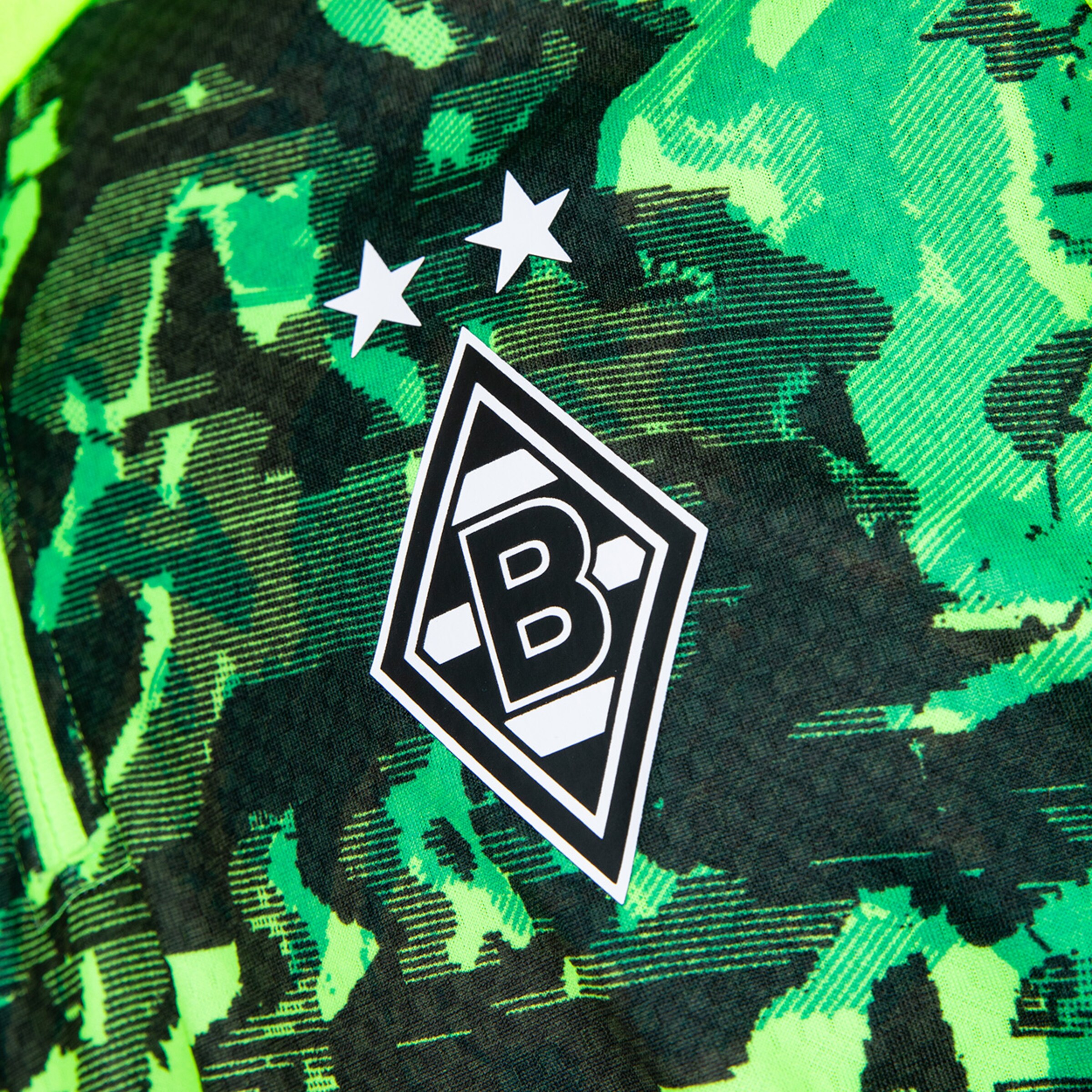 Logo von Borussia Mönchengladbach auf einem Trikot mit grünem Muster.