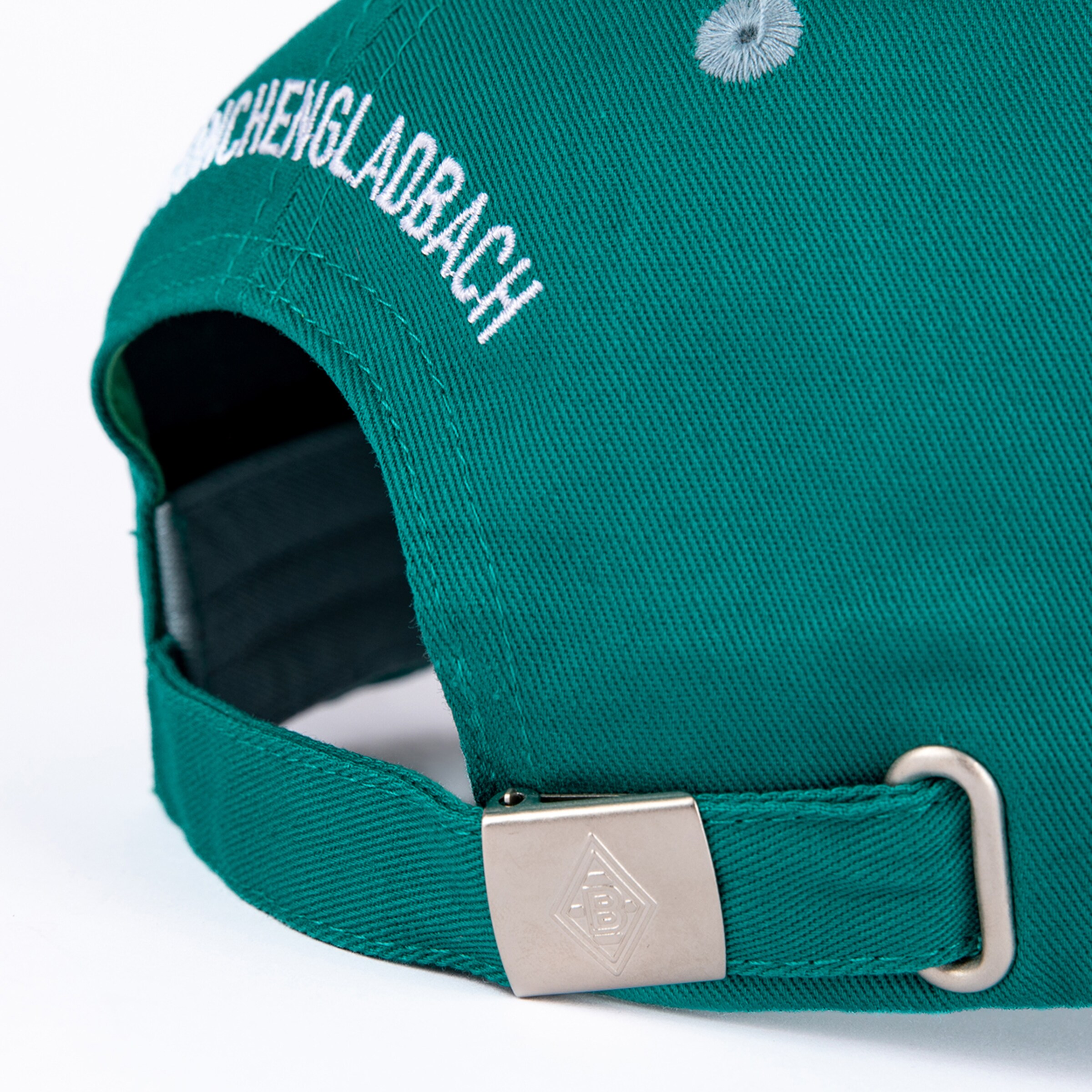 Detailaufnahme einer grünen Basecap mit weißer 'CHENGLADBACH'-Stickerei am Hinterkopf. Die verstellbare Lasche hat eine silberne Schnalle mit dem Borussia Mönchengladbach Logo.