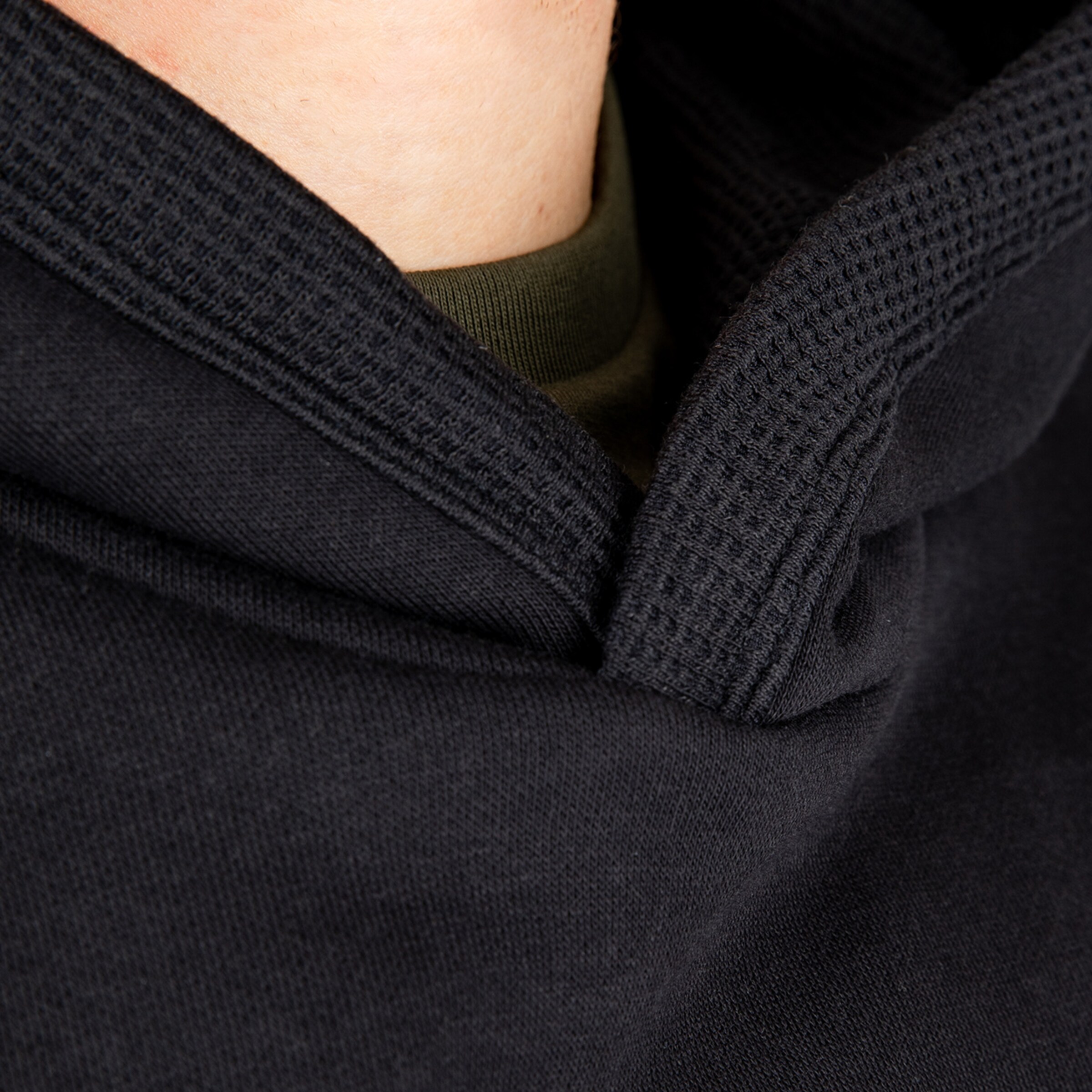 Detailaufnahme eines schwarzen Hoodie-Kragens mit Textur.