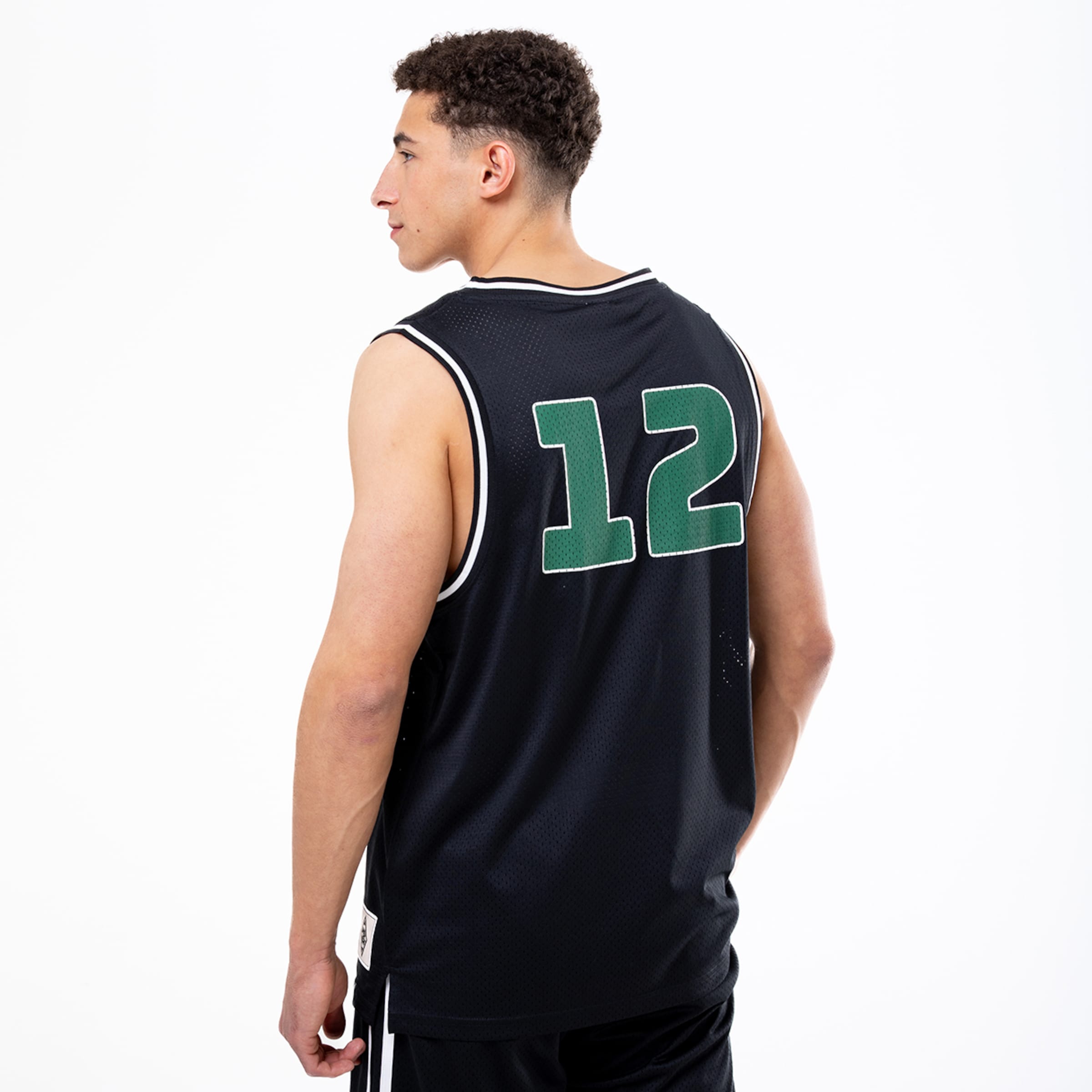 Rückansicht eines Mannes in schwarzem Basketball-Trikot mit grüner Nummer 12 und weißem Saum vor weißem Hintergrund.