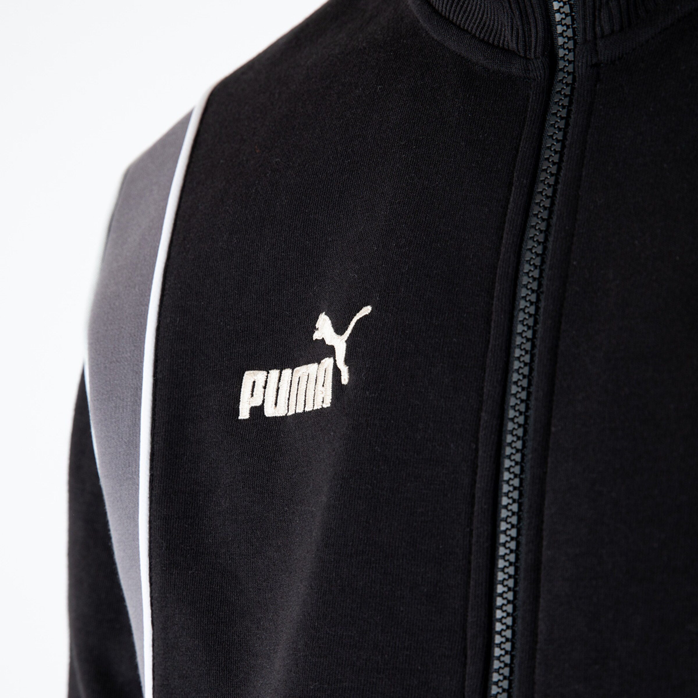 Schwarze Trainingsjacke von Puma mit weißem Logo und Reißverschluss.