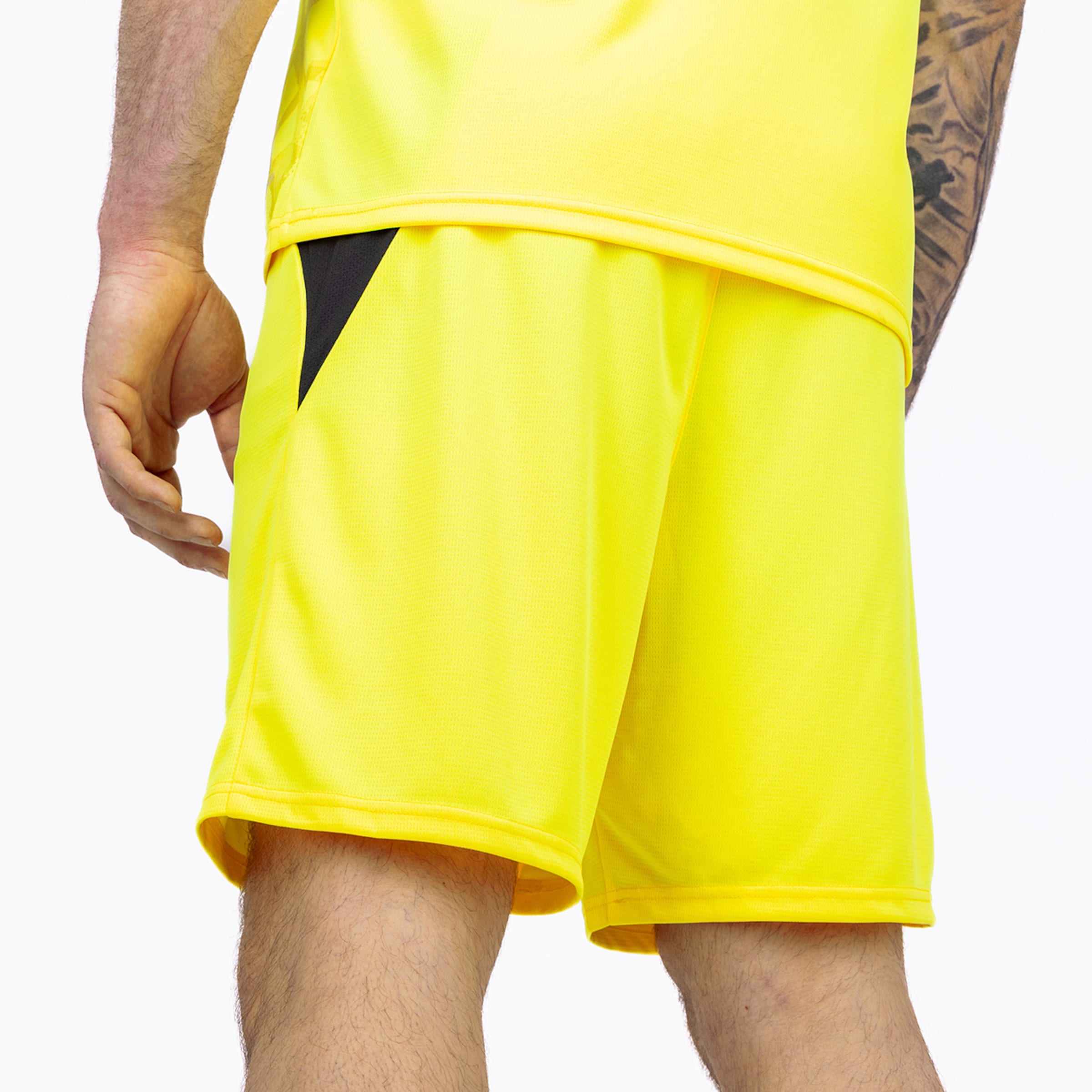Back view of yellow athletic shorts and matching jersey with a black contrast panel on a white background.