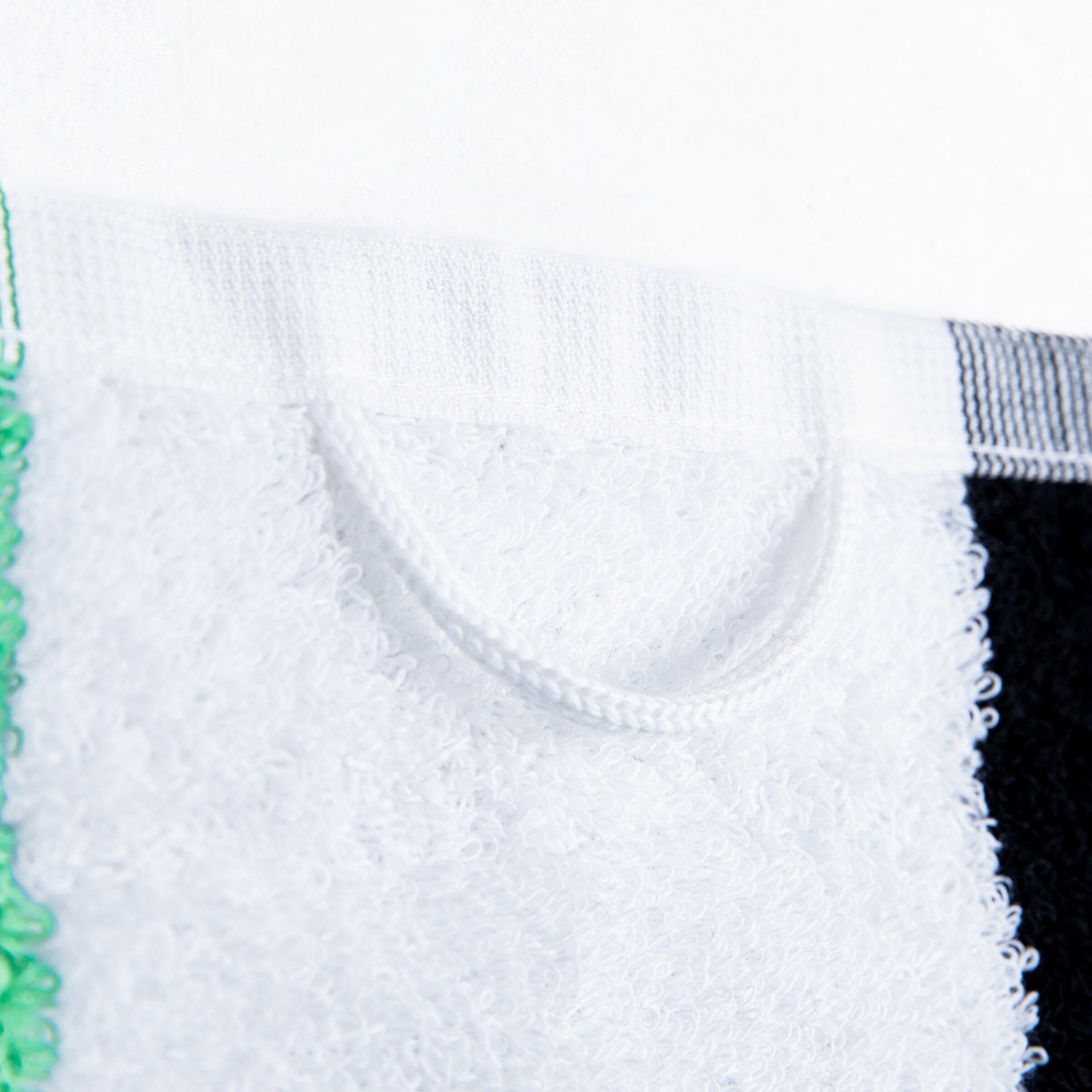 Close-up of a towel in black white and green colors featuring a hanging loop.