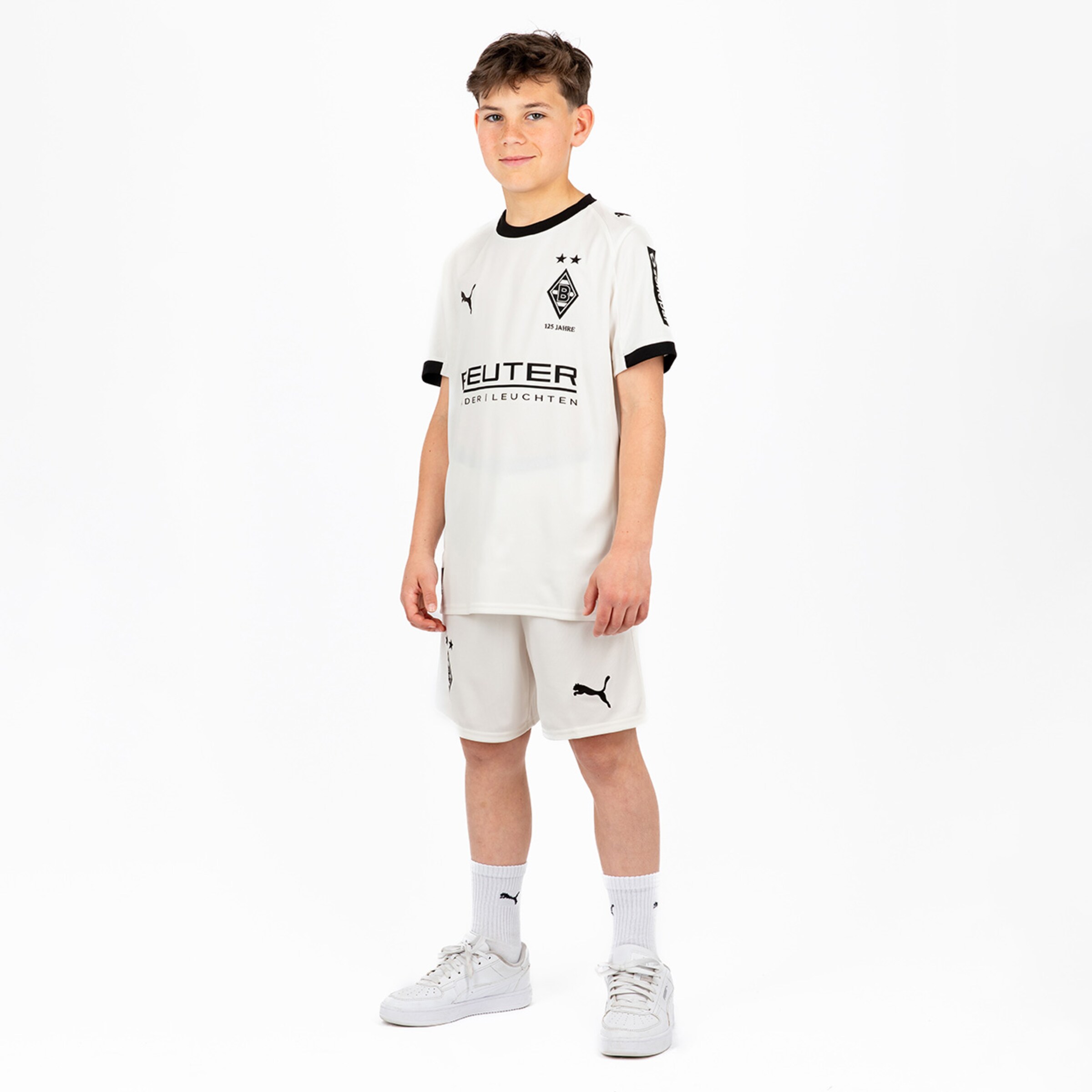 Ein Junge trägt das weiße Heimtrikot von Borussia Mönchengladbach mit Schwarz und Puma-Logo.