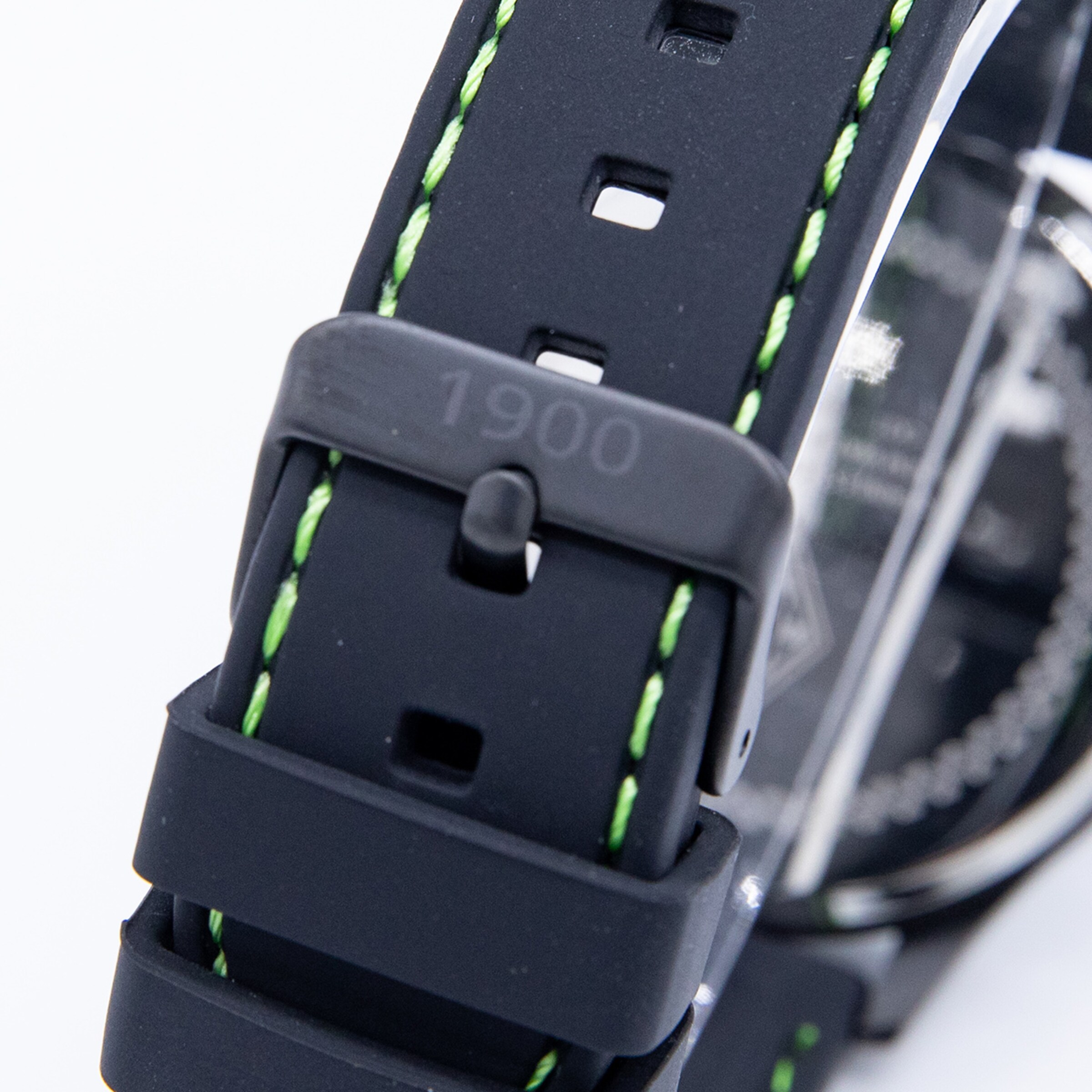 Schwarzes Armband einer Uhr mit grünen Nähten und der Prägung 1900 auf dem Schließe.