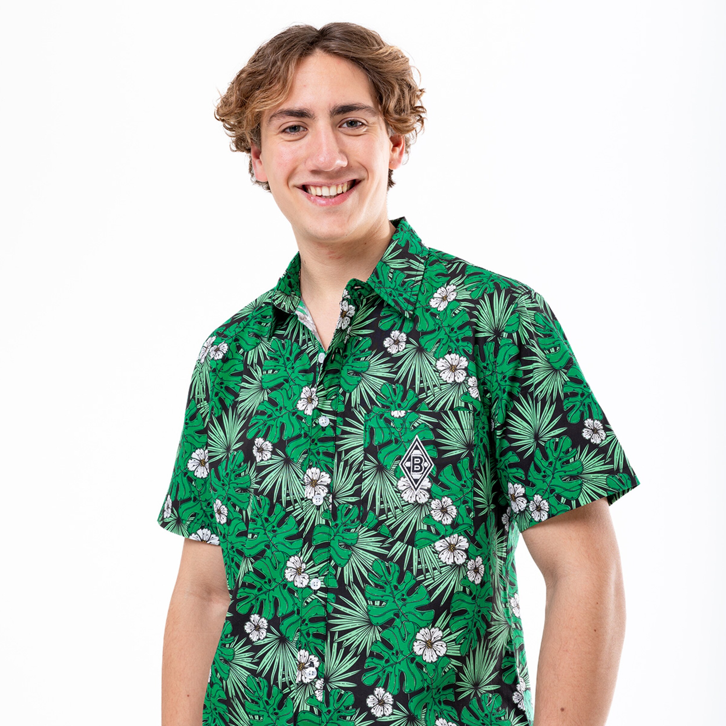 Junger Mann in einem bunten Hawaii-Hemd mit Blumenmuster und Logo von Borussia Mönchengladbach.