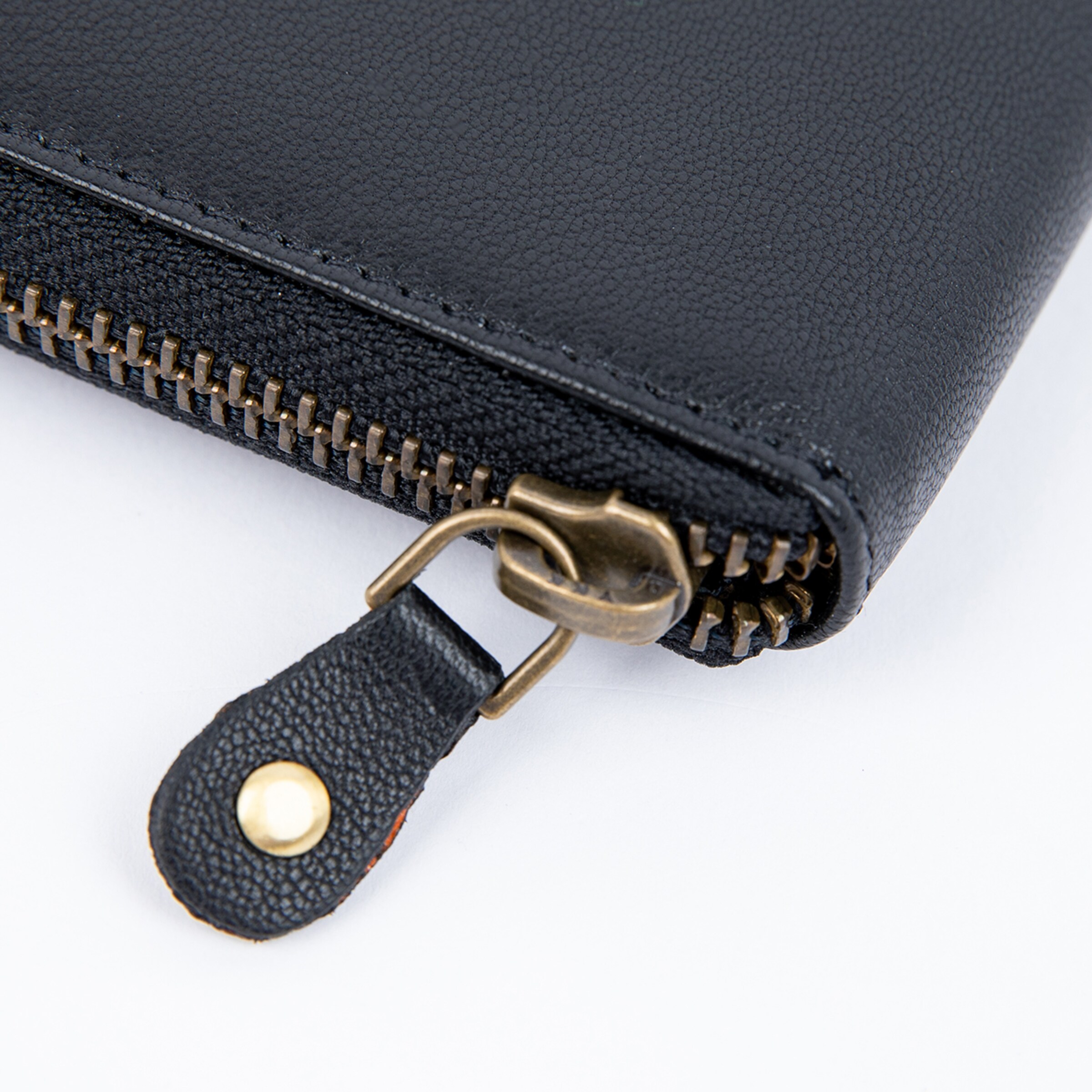 Black wallet featuring a visible zipper and a practical tag.