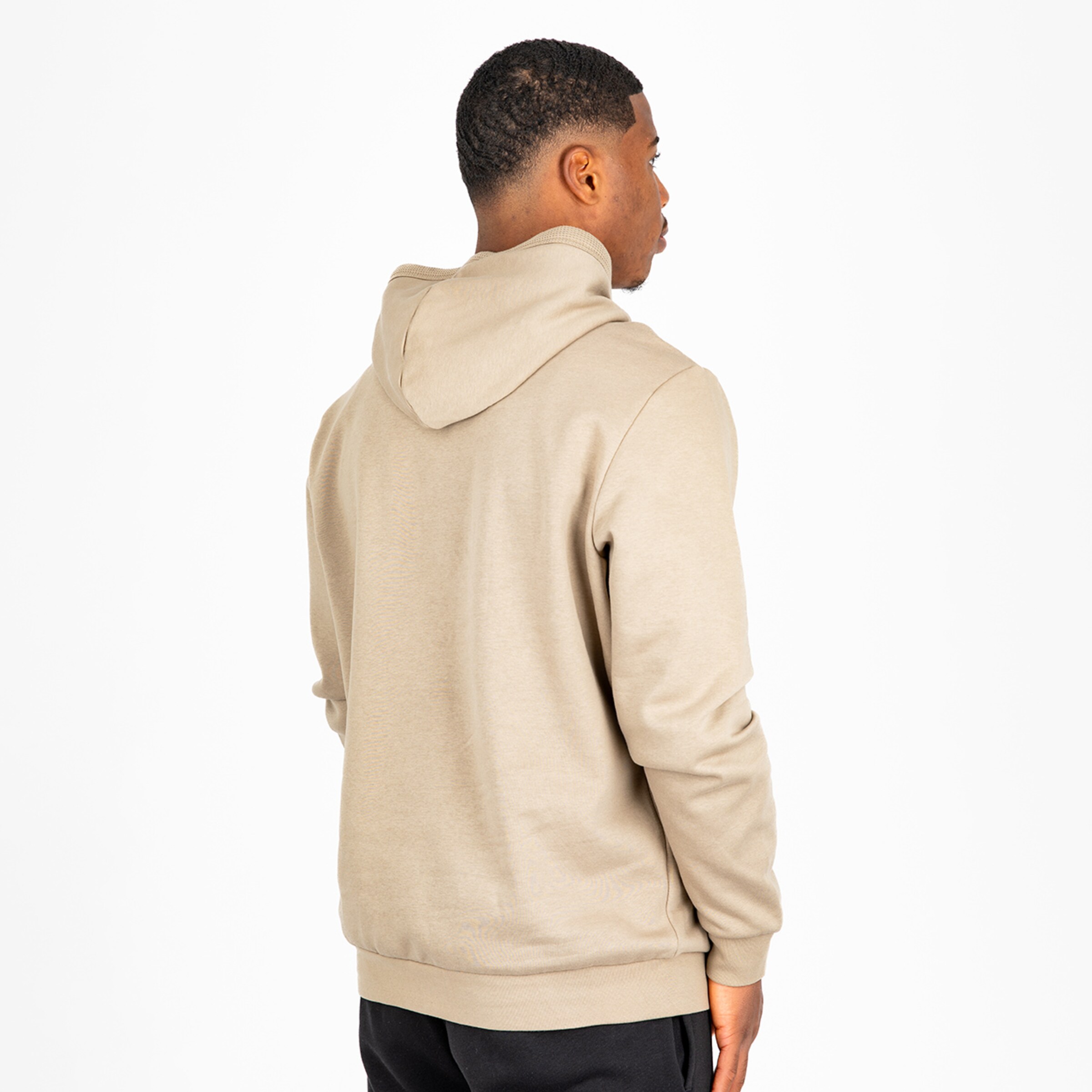 Person wearing a light beige hoodie seen from the back.