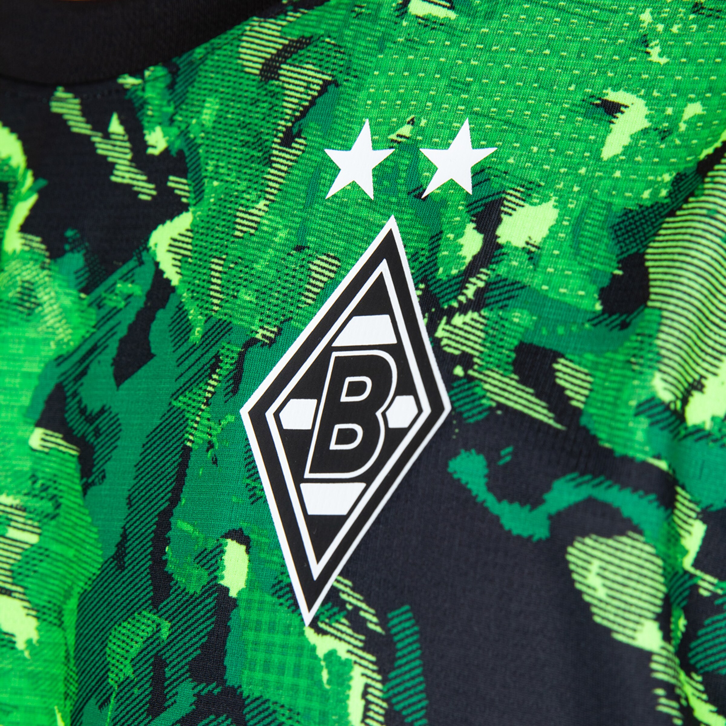 Grünes Trikot mit schwarzem und grünem Muster zeigt das Vereinslogo von Borussia Mönchengladbach mit zwei Sternen.