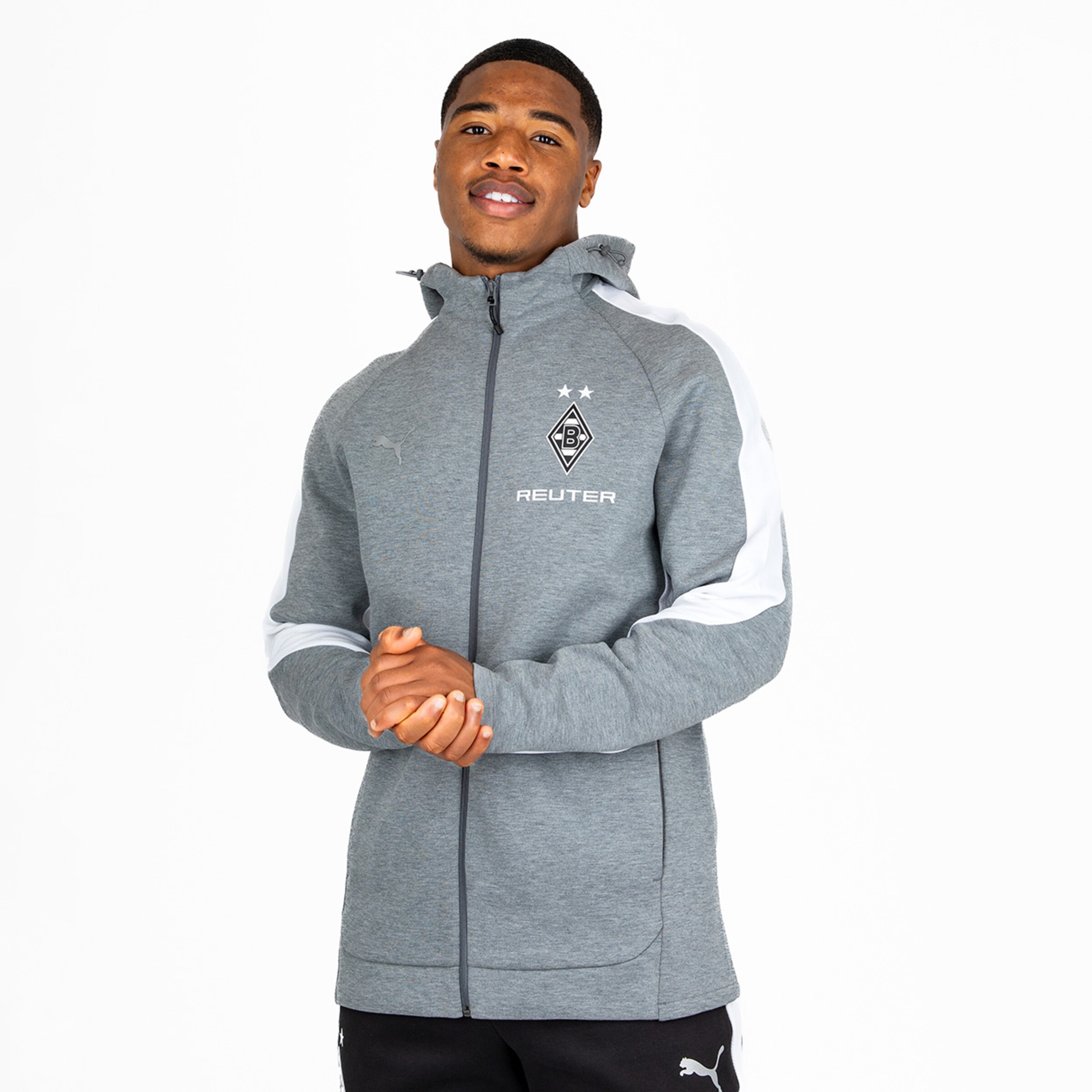 Mann trägt graue Sportjacke mit aufgesticktem Logo von Borussia Mönchengladbach.