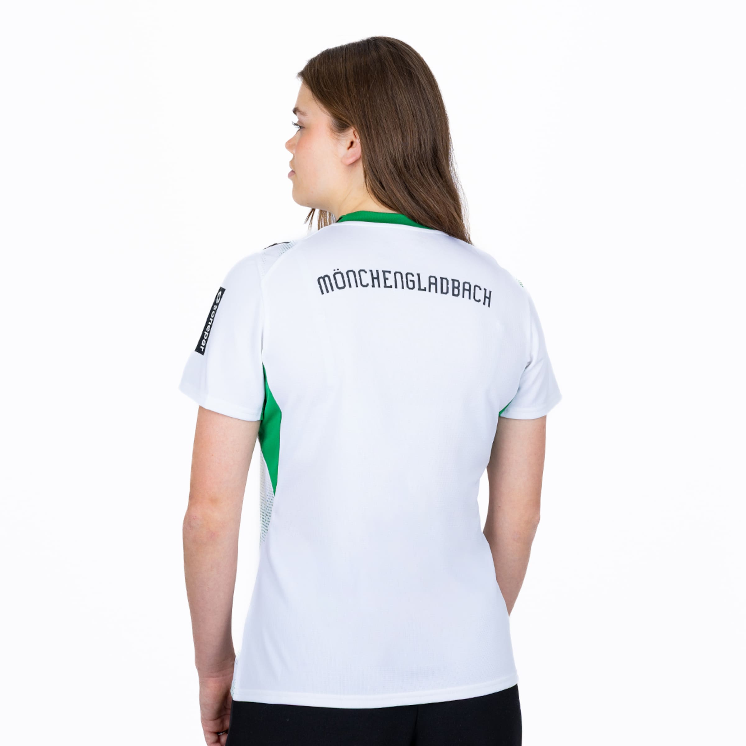 Rückansicht einer Frau im weißen Trikot mit dem schwarzen Schriftzug „MÖNCHENGLADBACH“ und grünen Akzenten an den Seiten.