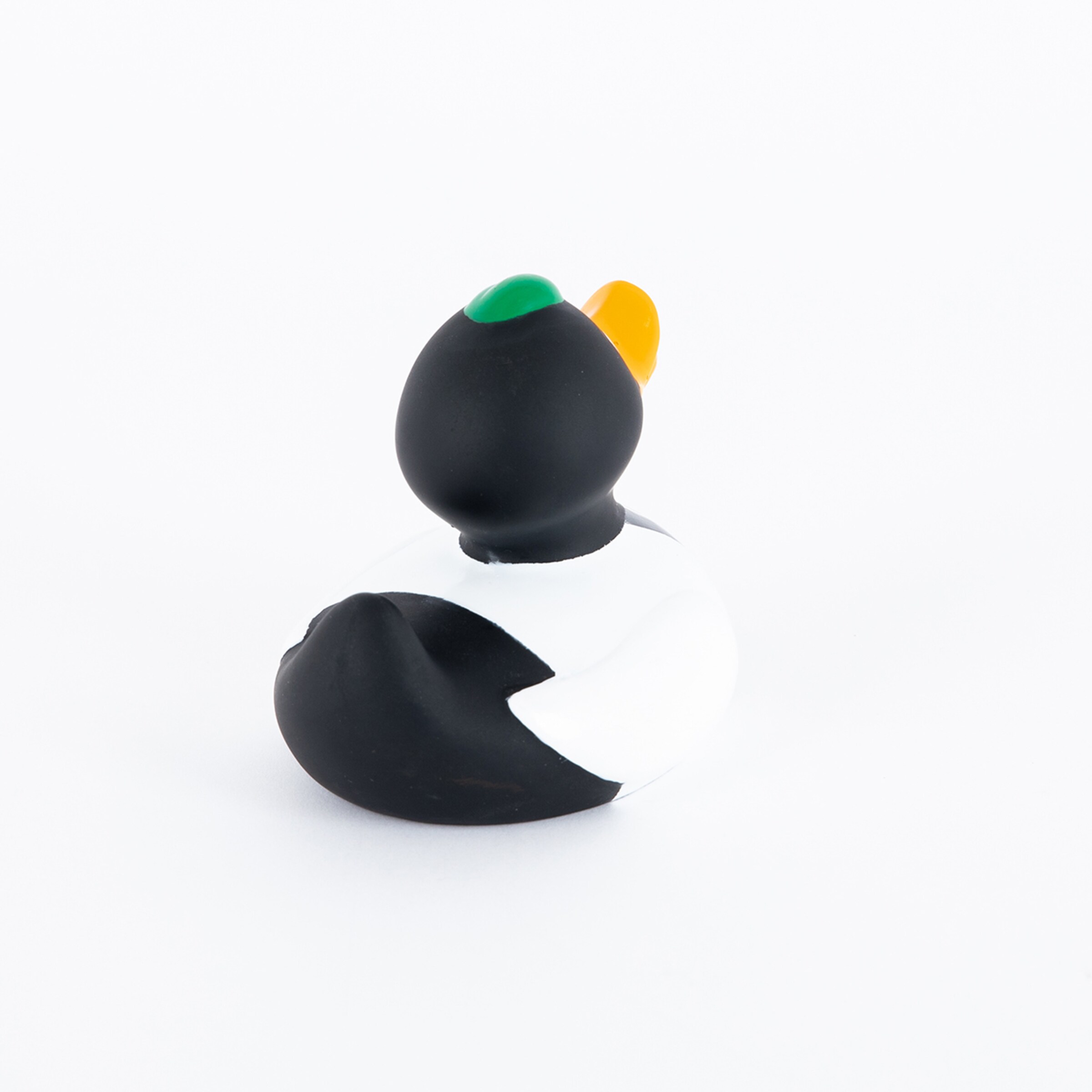 Rubber duck in black and white with colorful hat from the back
