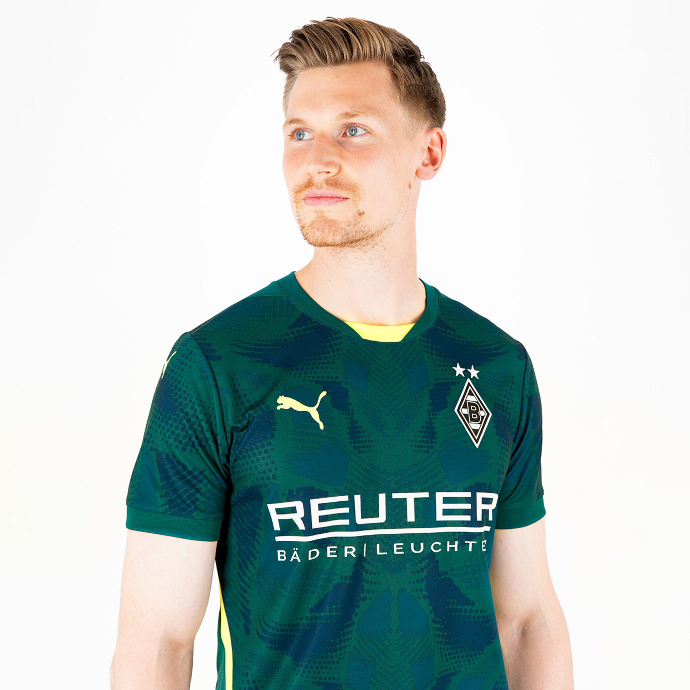 Ein Spieler von Borussia Mönchengladbach trägt das grüne Trikot mit gelben Akzenten und dem Sponsorenlogo REUTER.