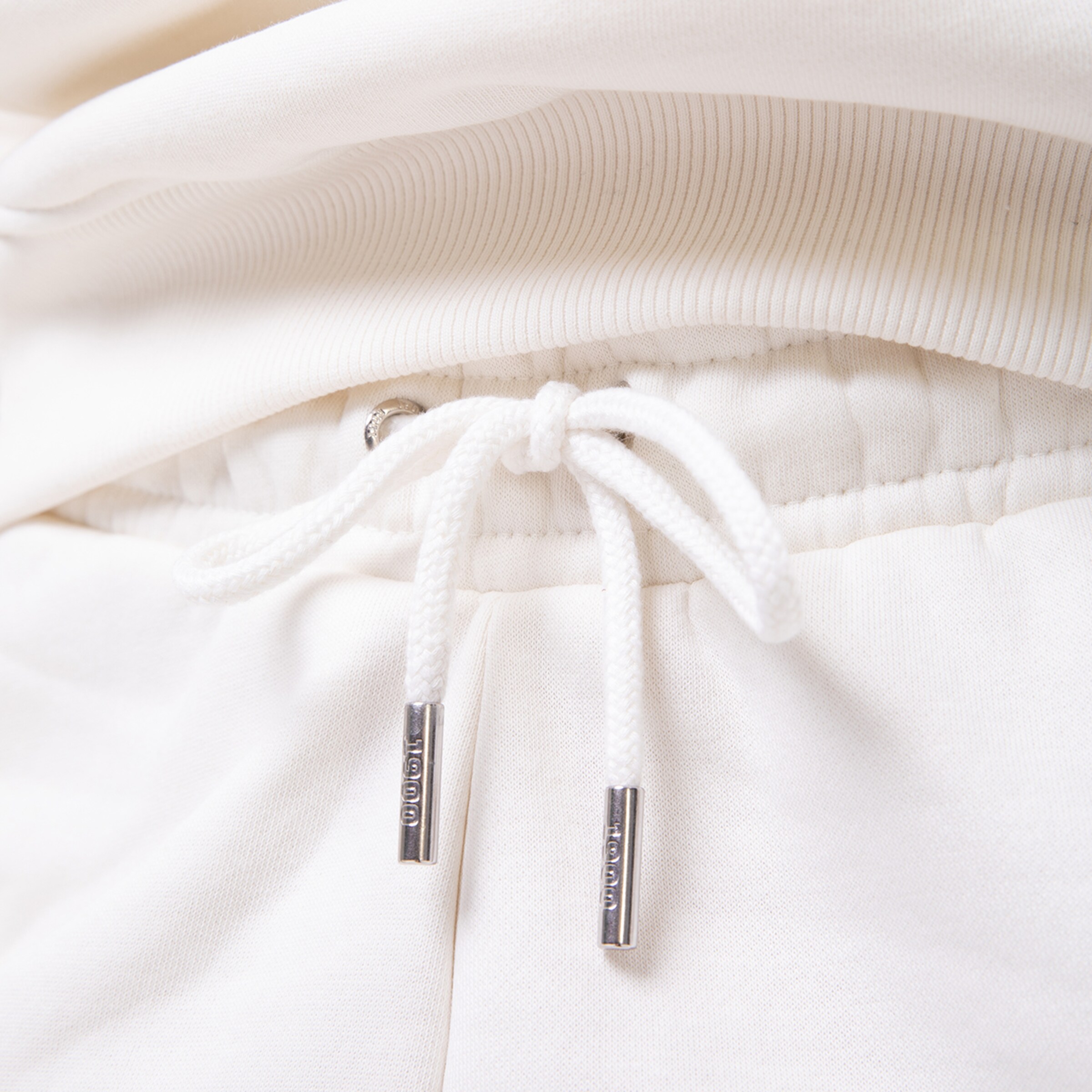 Weißer Kordelzug an einer beigen Sporthose