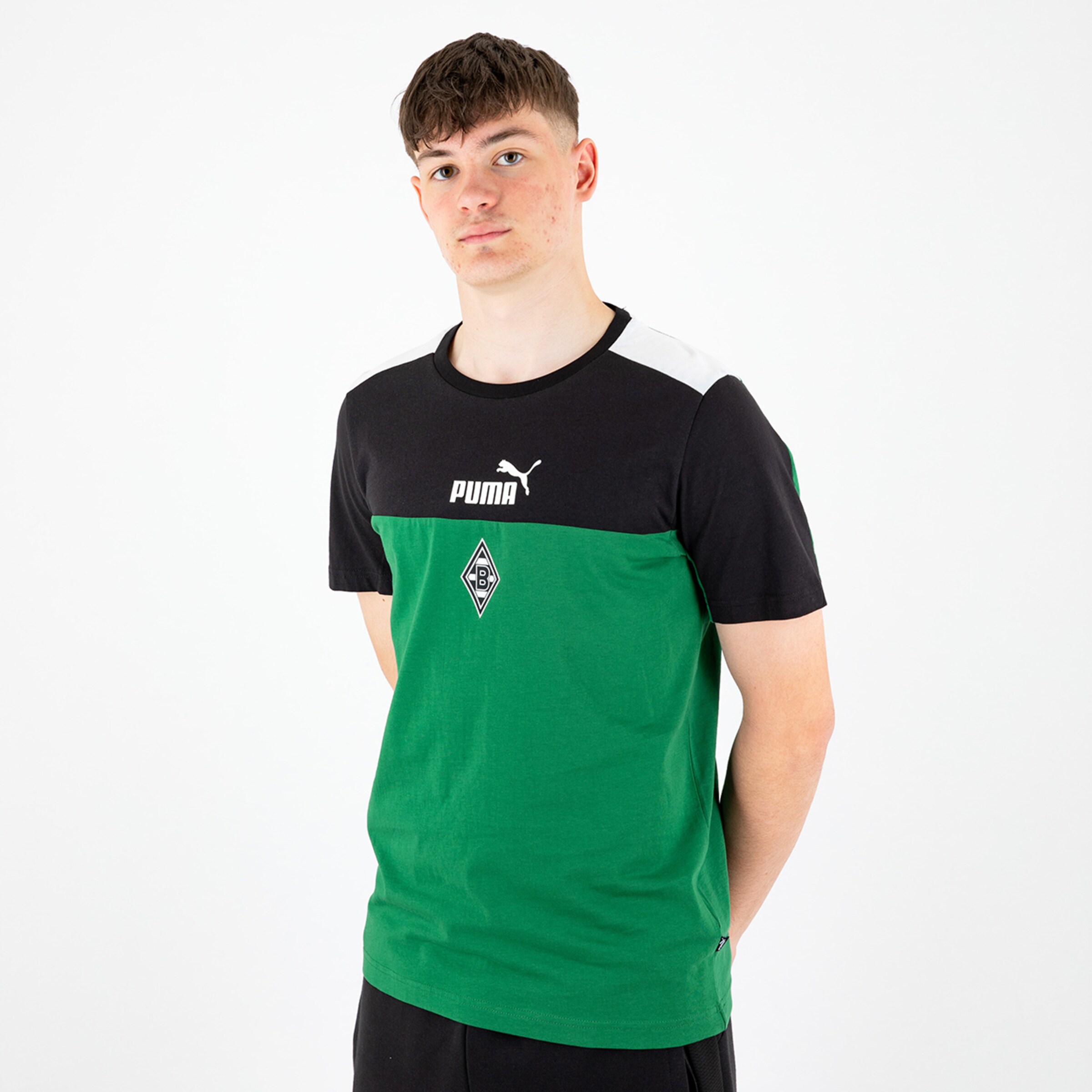Young man wearing a green and black Puma t-shirt featuring the Borussia Mönchengladbach logo.