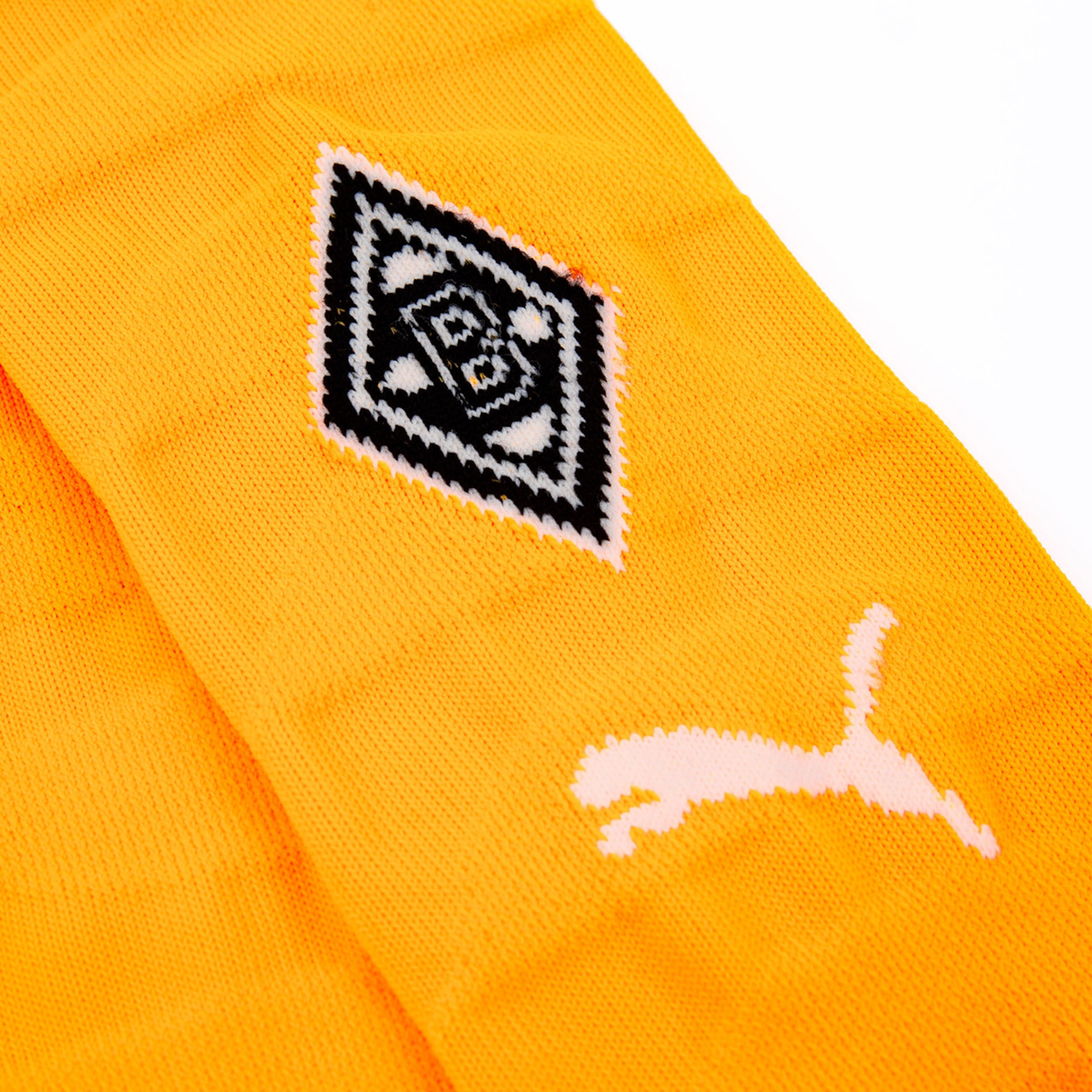 Schwarzes Borussia Mönchengladbach-Logo auf einem gelben Shirt mit PUMA-Logo in Weiß.