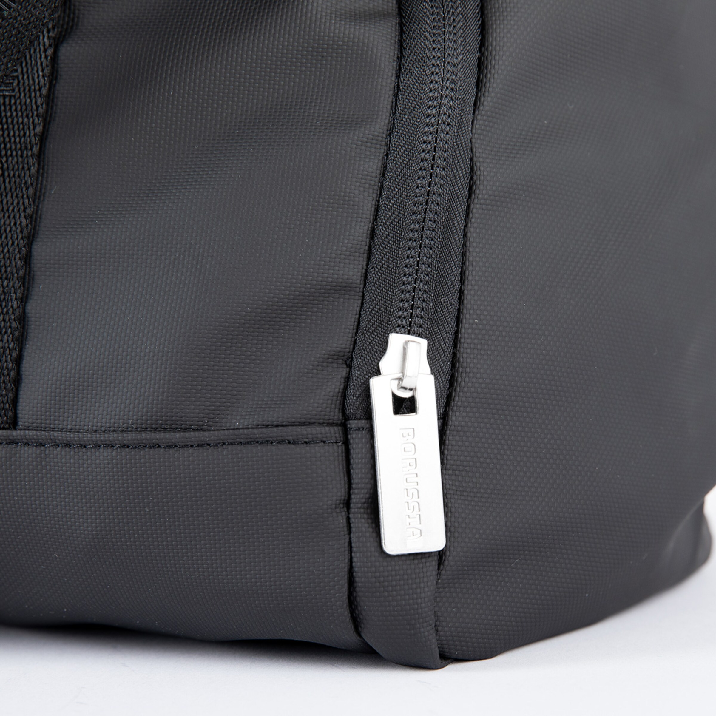 Schwarze Tasche mit Reißverschluss und einem silbernen Anhänger.