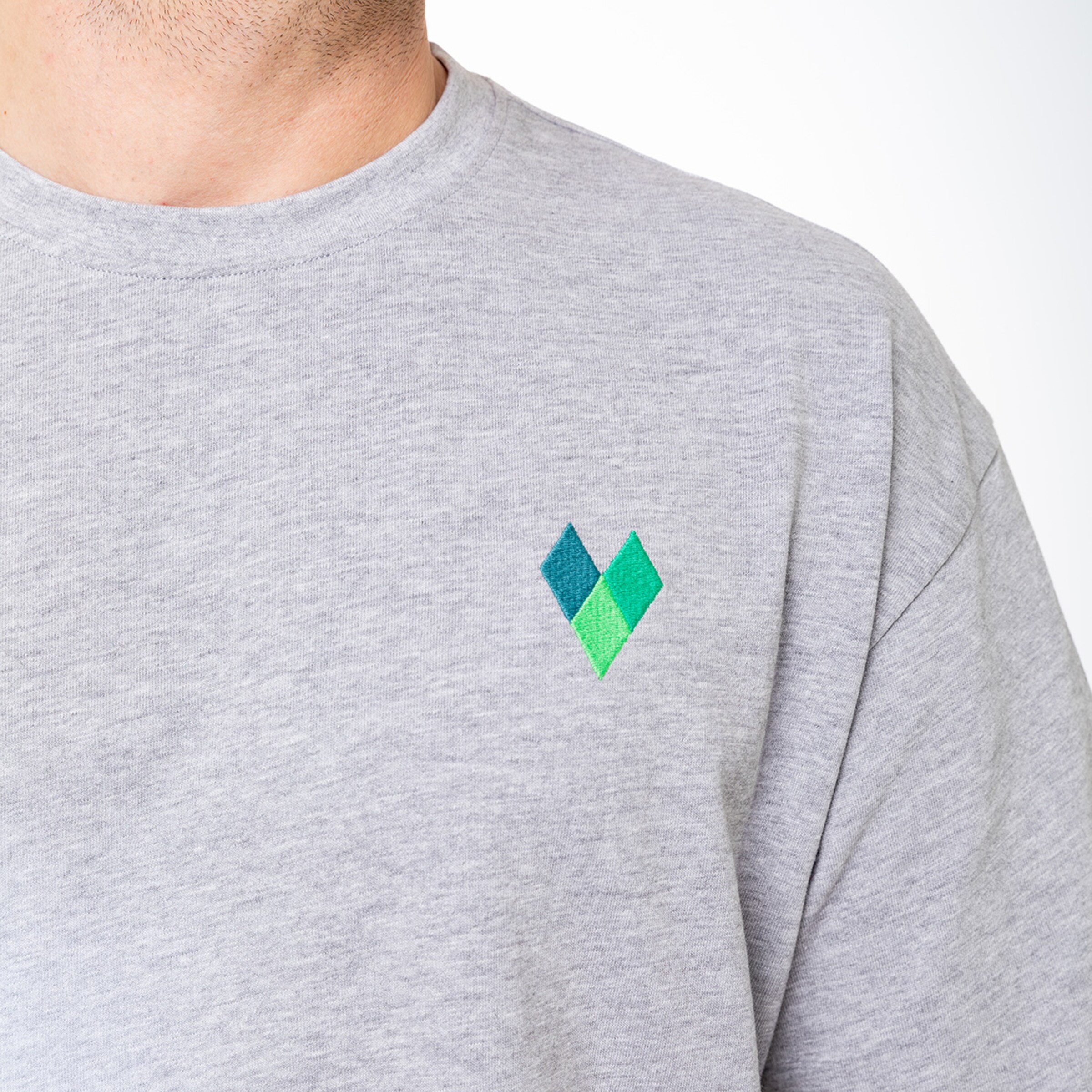 Graues Sweatshirt mit grün-blauem geometrischem Logo auf der linken Brust.