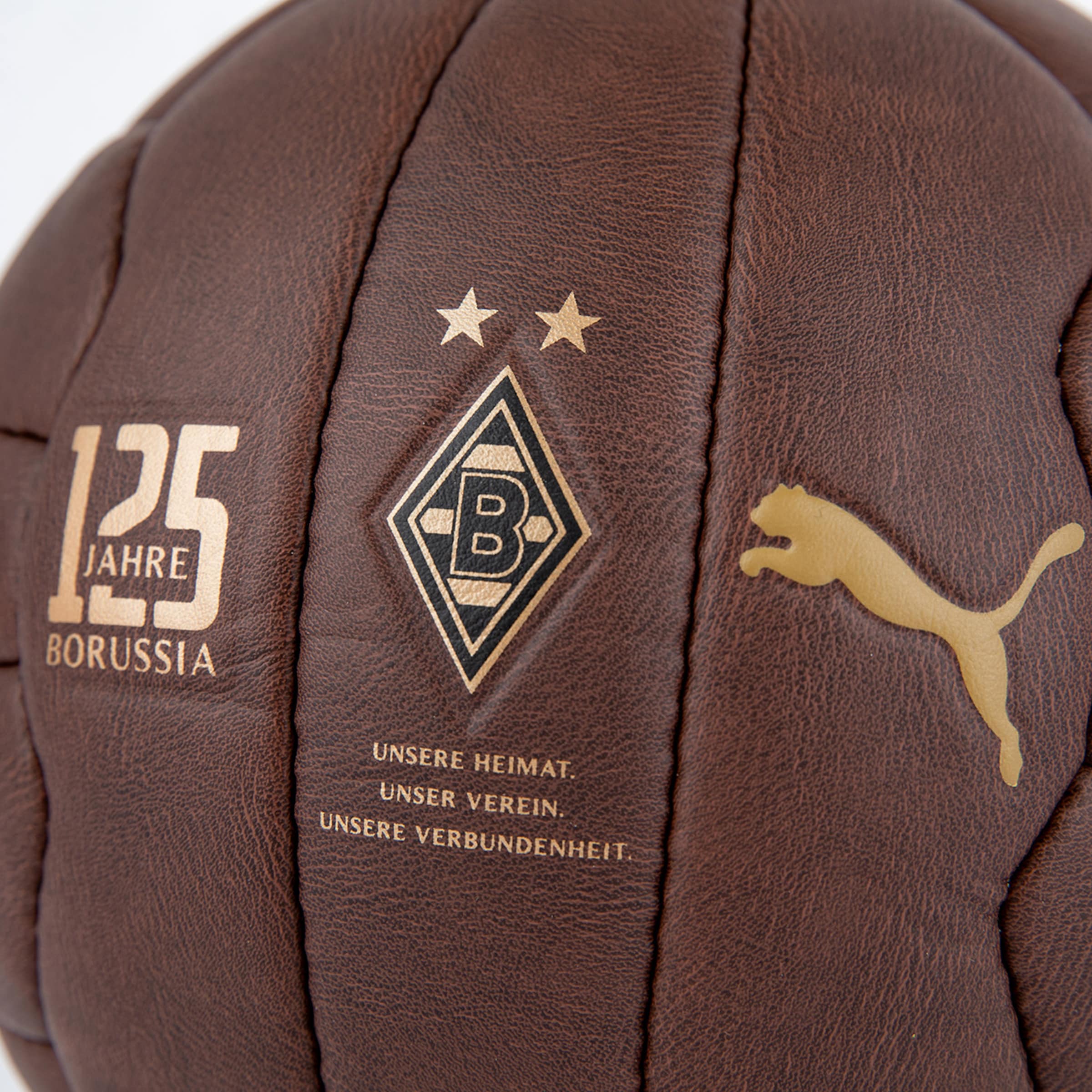 Brauner Retro-Lederball mit goldenem Borussia-Mönchengladbach-Wappen, 125-Jahre-Schriftzug, Puma-Logo und Vereinsmotto.