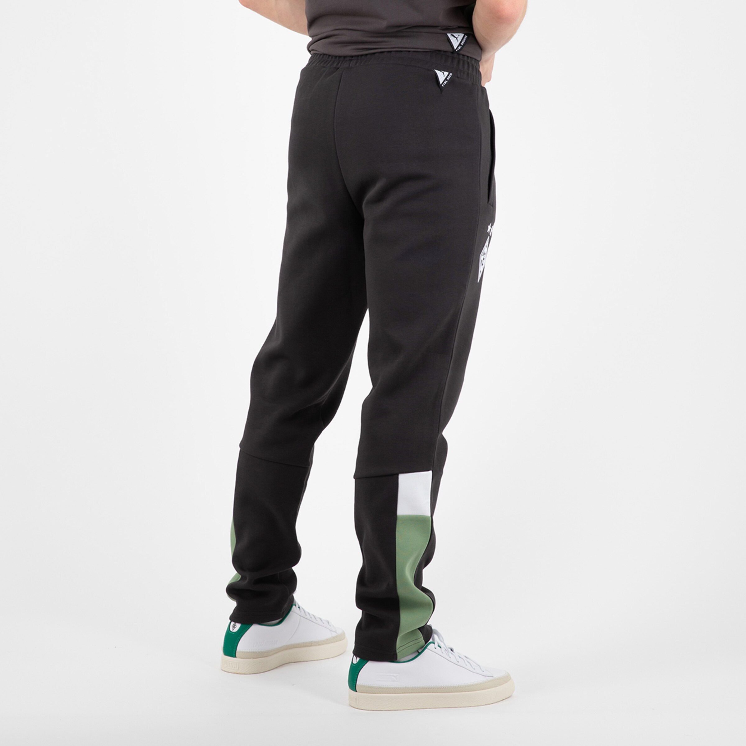 Schwarze Jogginghose mit grünem Streifen.