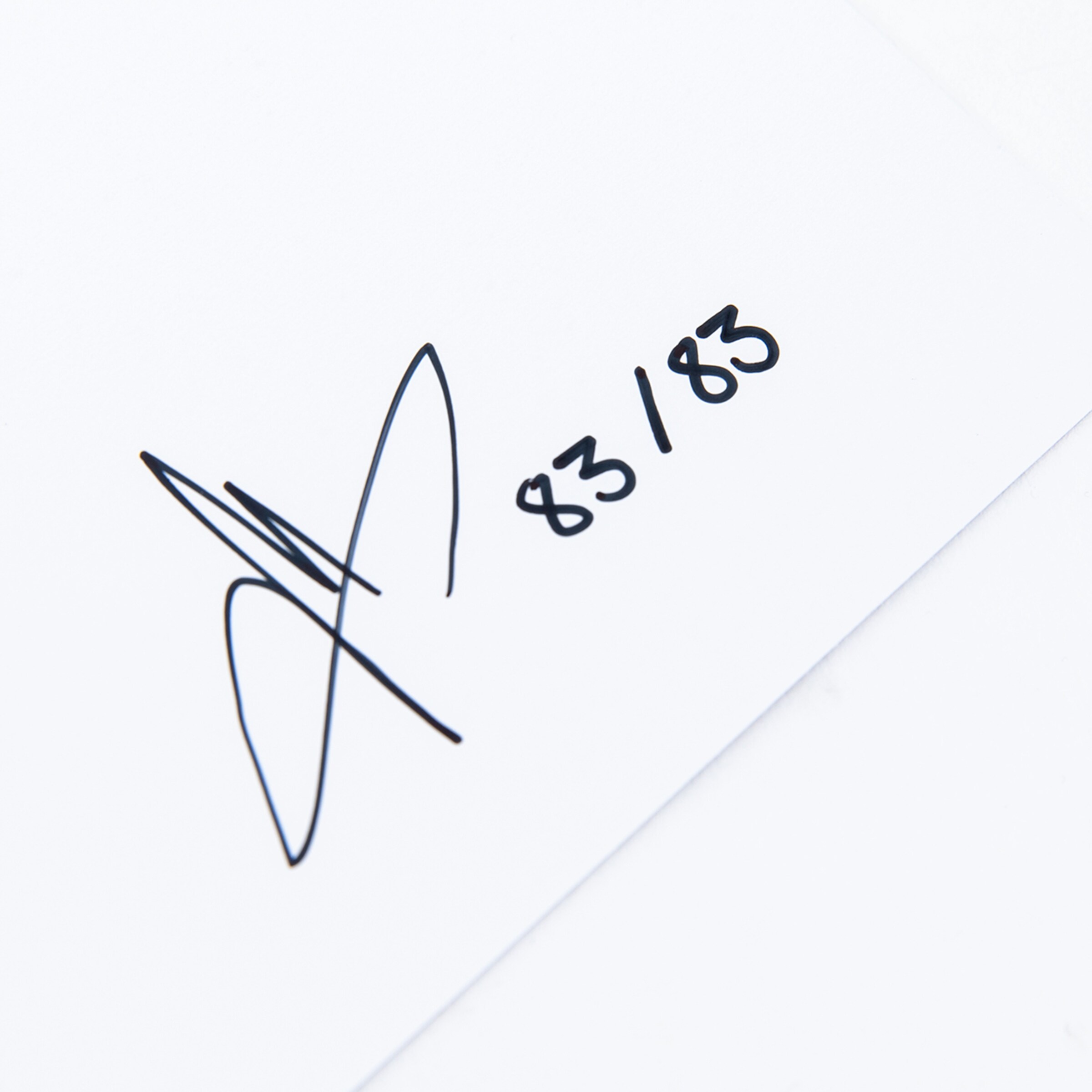 Handschriftliche Signatur und die Limitierungsnummer „83/183“ in schwarzer Tinte auf weißem Hintergrund.