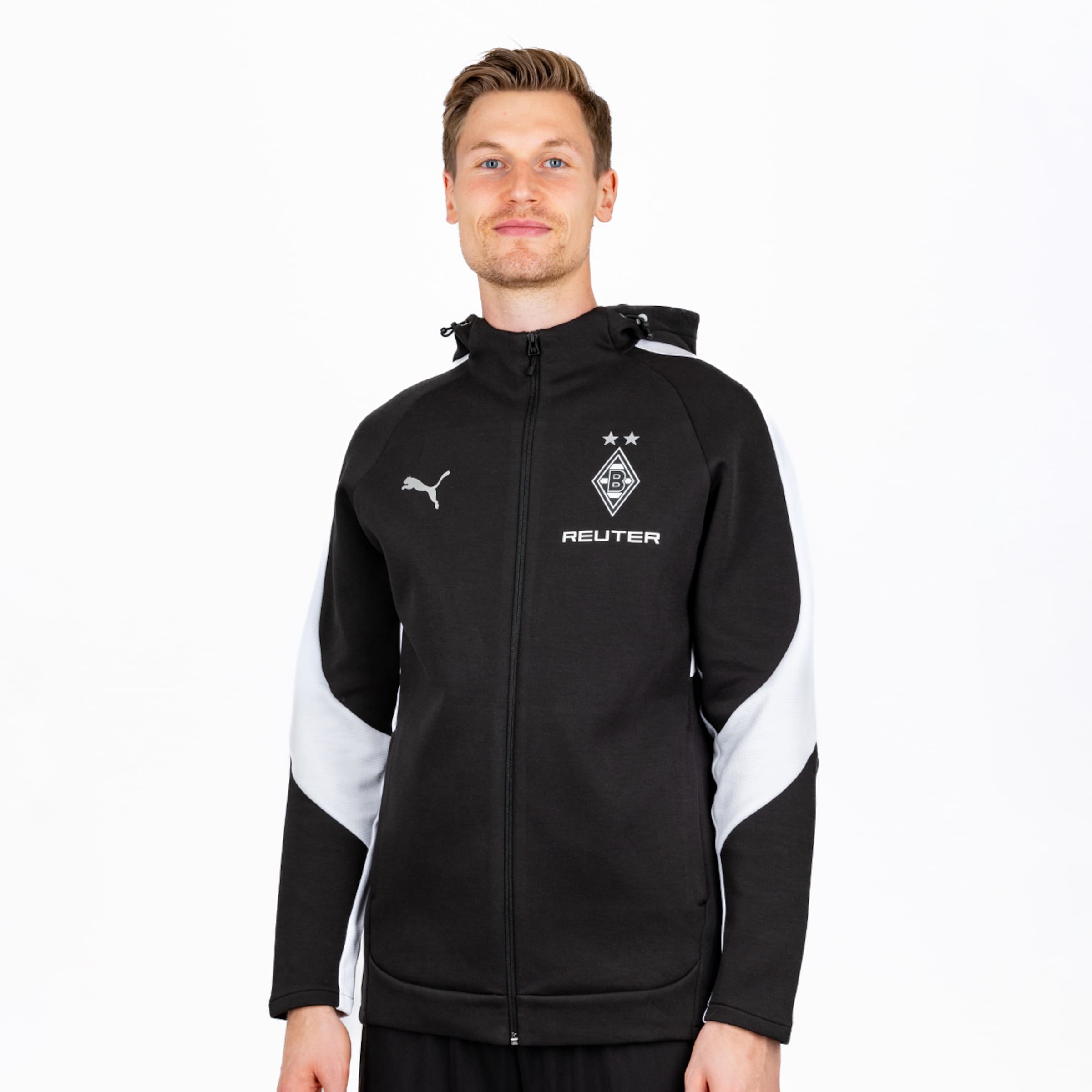Mann trägt schwarze Puma Hoodie-Jacke mit weißen Akzenten, Borussia Mönchengladbach Logo und REUTER Schriftzug, vor weißem Hintergrund.