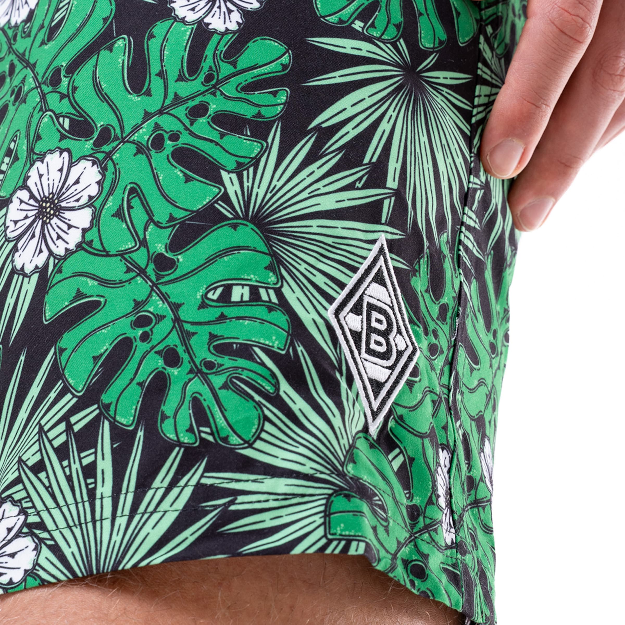 Badeshorts mit tropischem Blattmuster und Borussia Mönchengladbach-Logo.