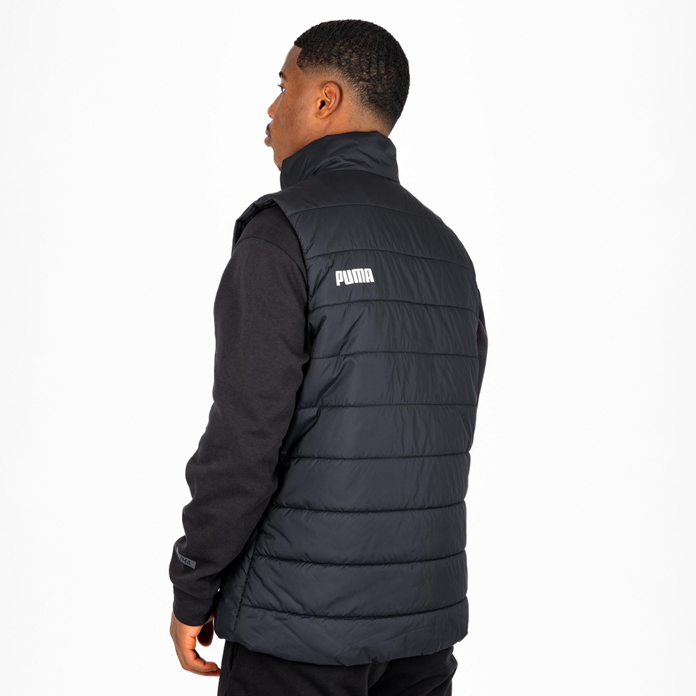 Man wearing a black Puma vest viewed from the back.