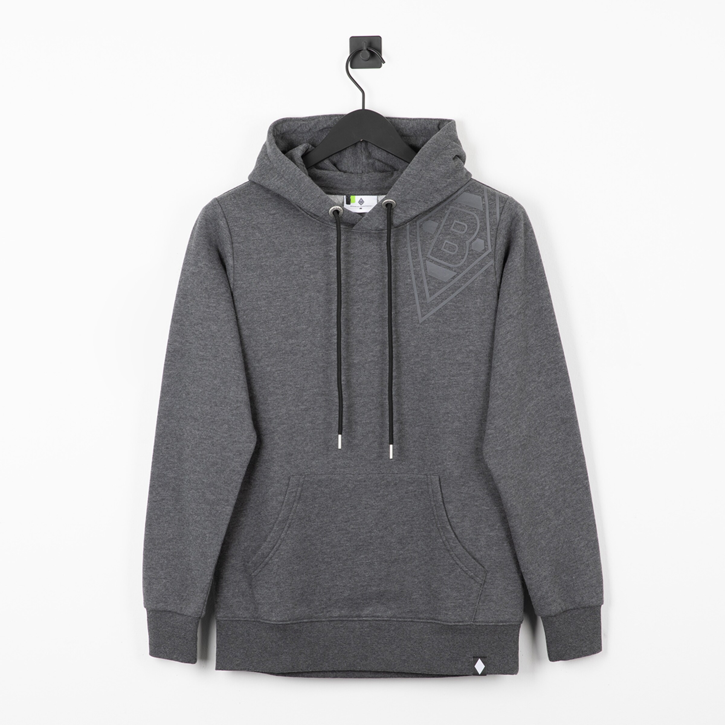 Grauer Hoodie mit Kängurutasche, schwarzen Kordeln und dezentem Rauten-Logo auf der Brust. Kleiner Aufnäher am unteren Saum.