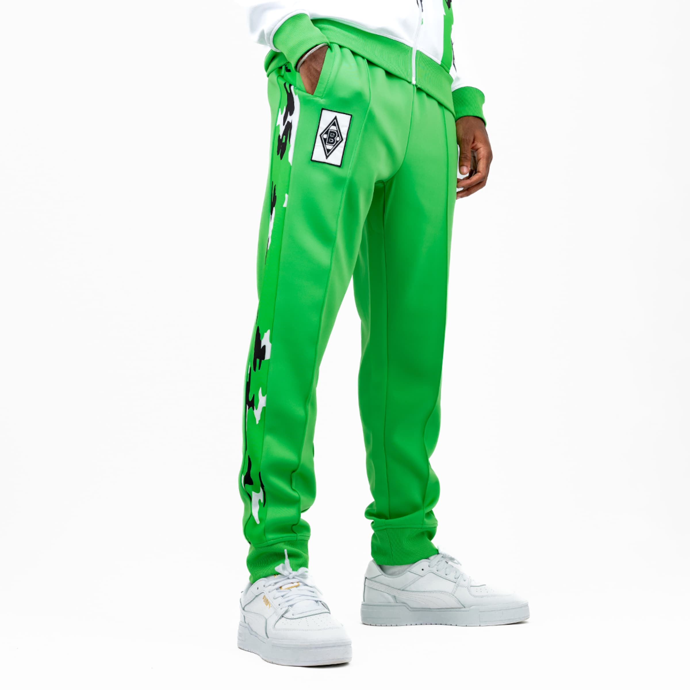 Grüne Jogginghose mit aufgenähtem Logo und Schwarz-Weiß-Muster.